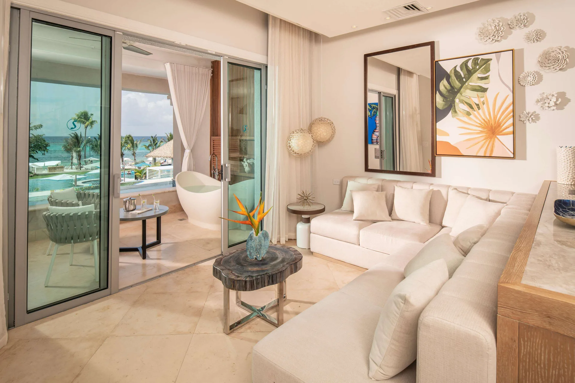 Suite lounge with balcony, soaking tub, and ocean view at Sandals Dunns River.