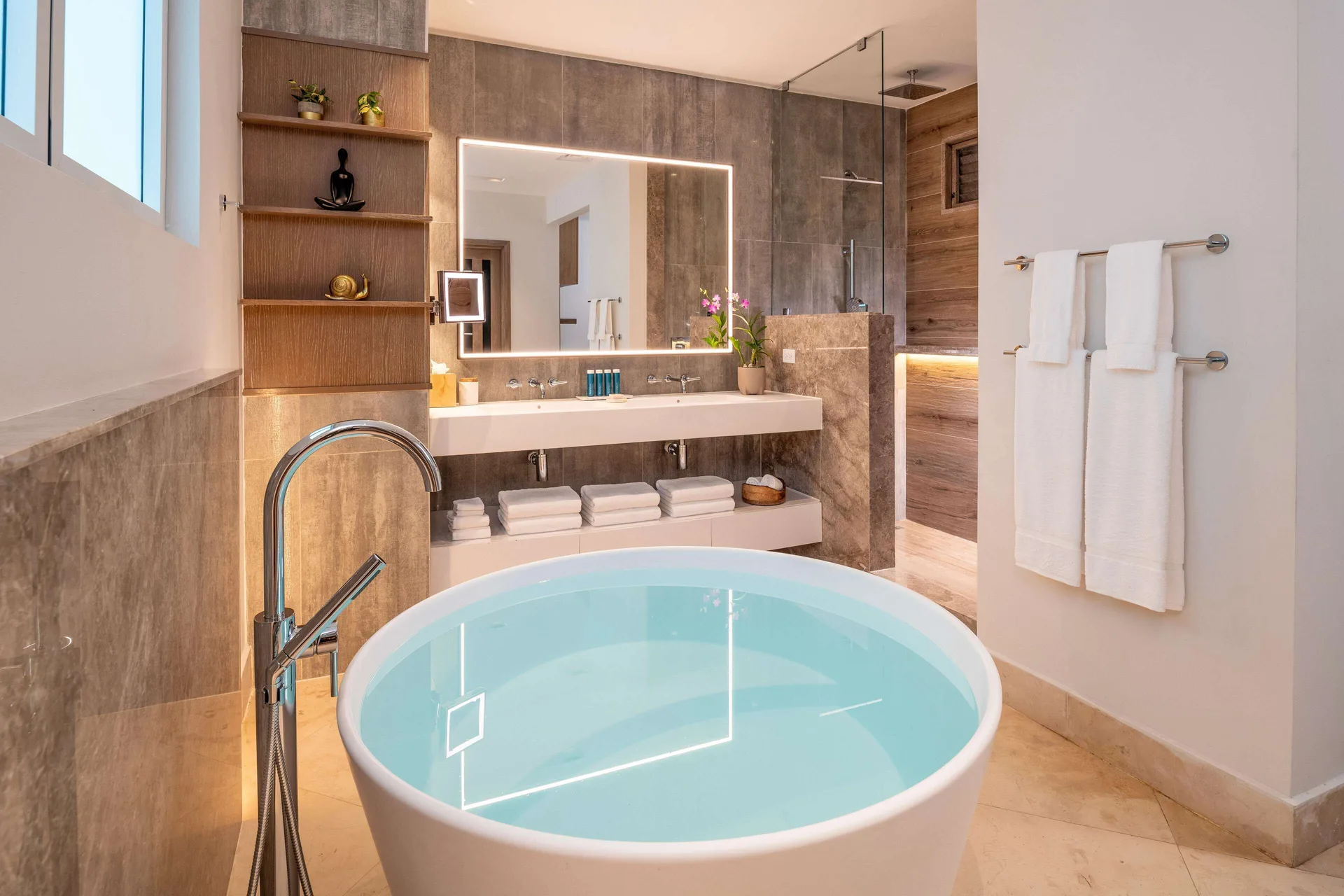 Suite bathroom at Sandals Dunns River with soaking tub, double vanity, and glass shower.
