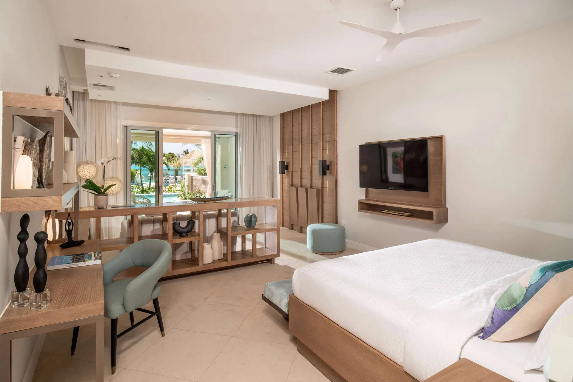 Guest room at Sandals Dunns River with king bed, desk, TV, and sliding doors to a swim-up patio.