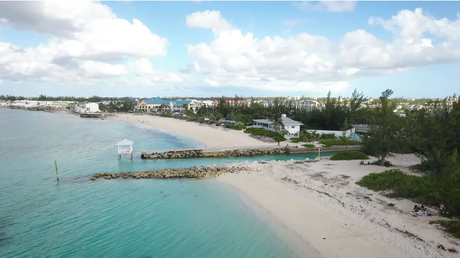 Aerial view of the beach, channel, and shoreline near Sandyport Beach Resort.