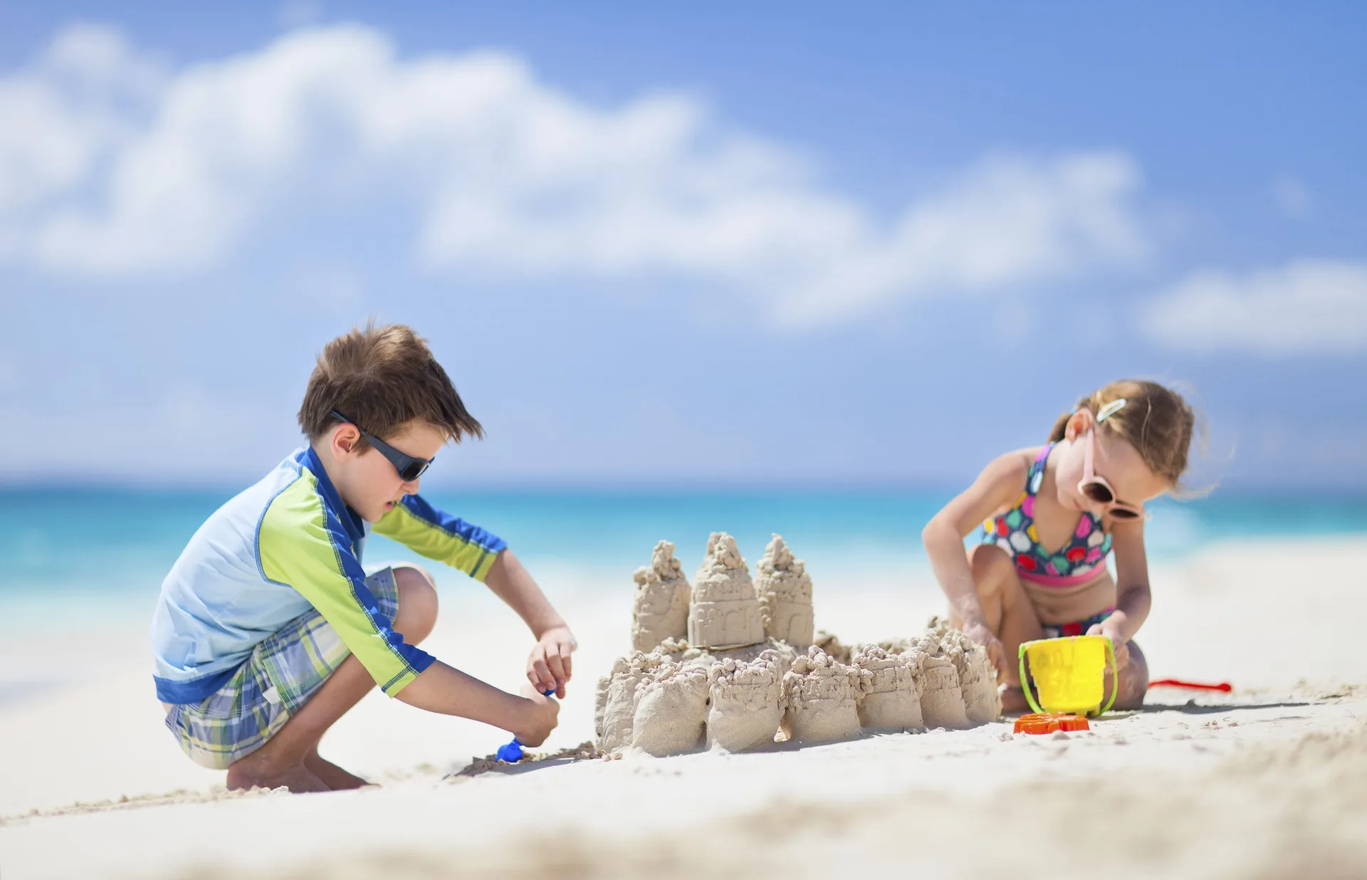Children building a sandcastle on the beach at Sandyport Beach Resort.