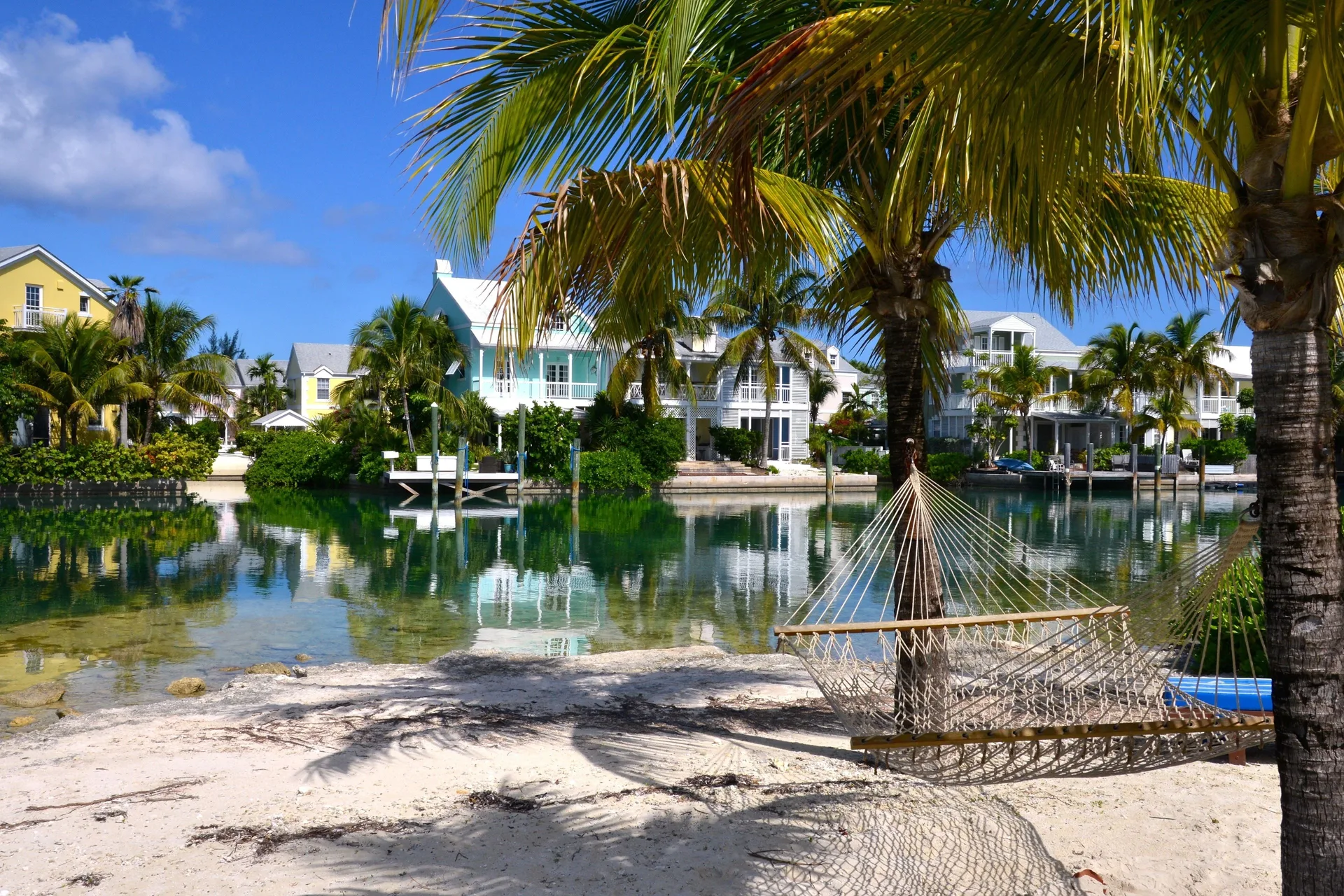 A hammock hangs under palms beside the lagoon at Sandyport Beach Resort.