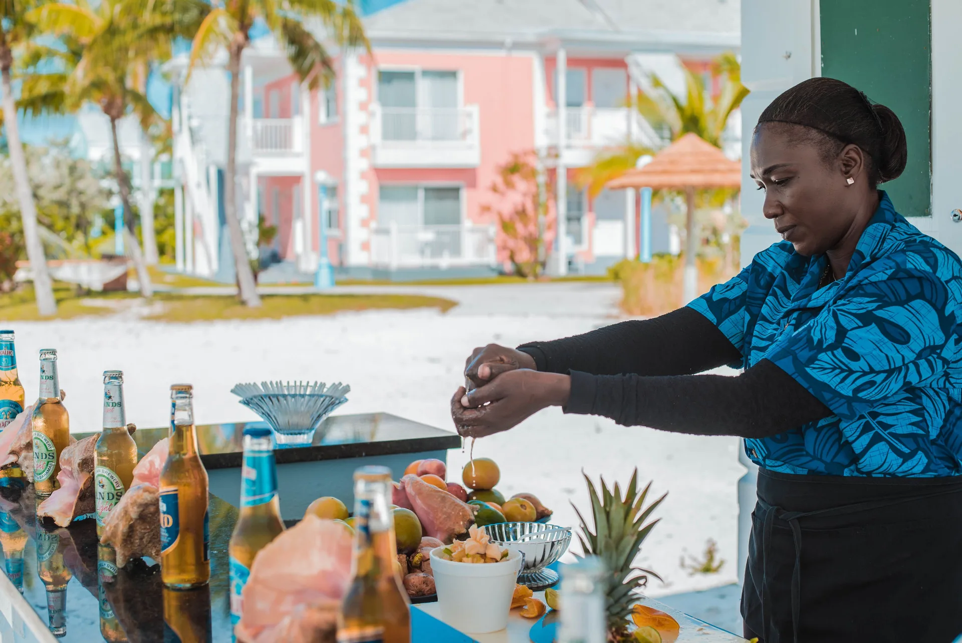 Staff member preparing fruit at an outdoor bar at Sandyport Beach Resort.
