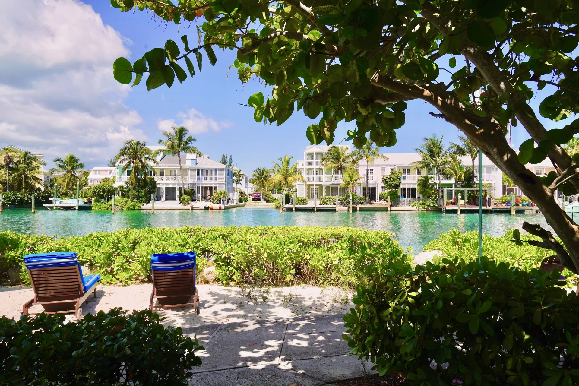 Deluxe suite patio view with loungers by the canal at Sandyport Beach Resort.