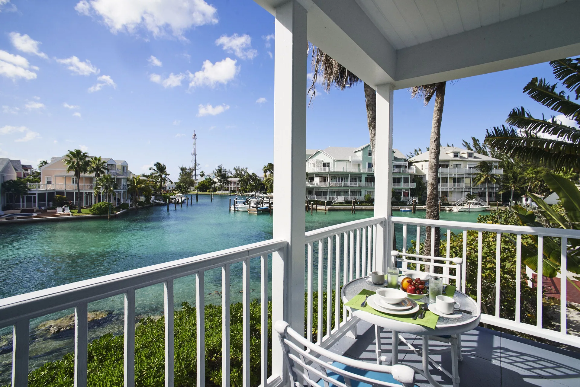 Deluxe suite balcony set for two overlooking the canal at Sandyport Beach Resort.