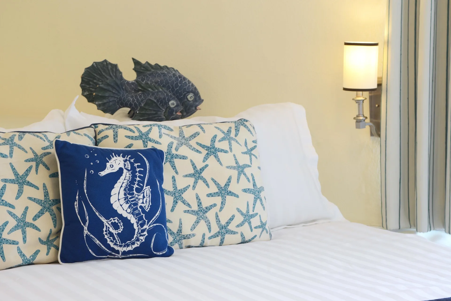 Deluxe suite king bed with coastal pillows at Sandyport Beach Resort.