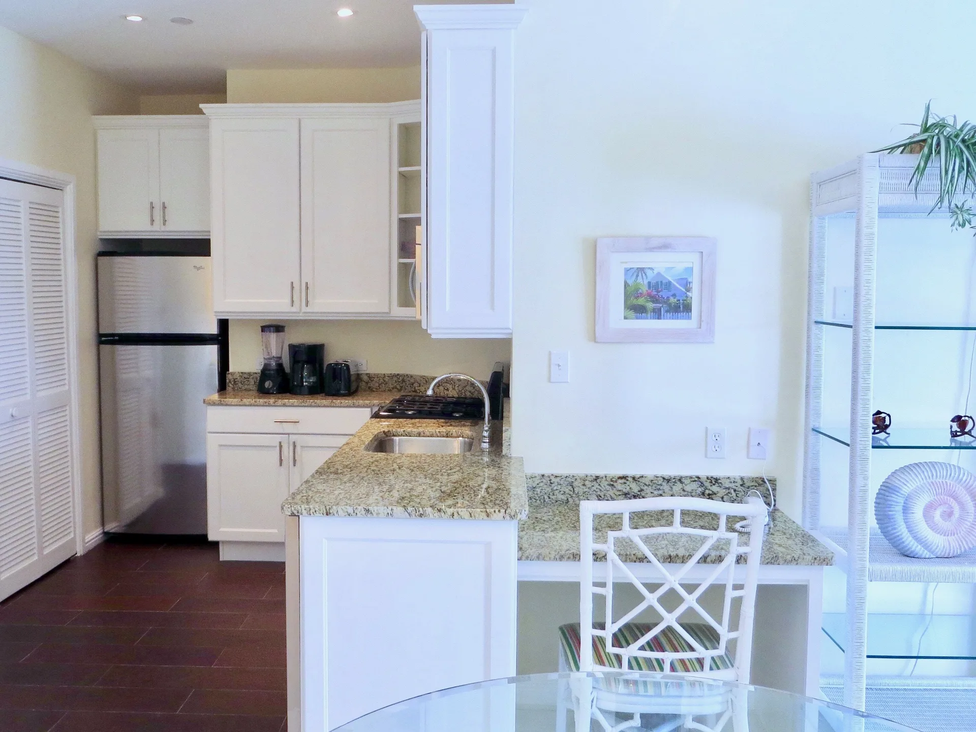 Deluxe suite kitchen with refrigerator and granite counter at Sandyport Beach Resort.