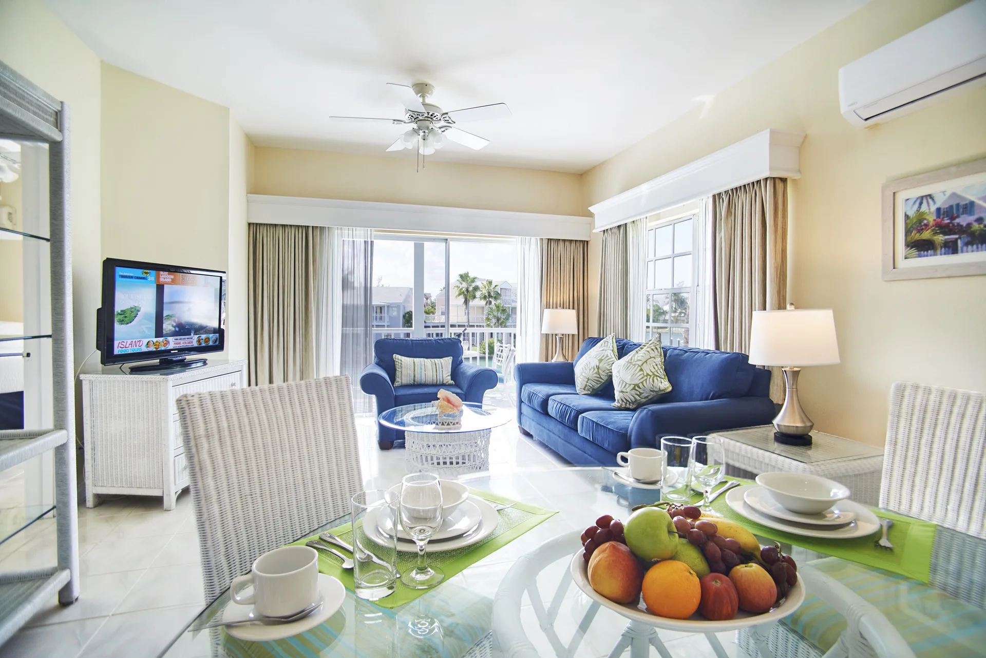 Deluxe suite living and dining area with blue sofabed at Sandyport Beach Resort.