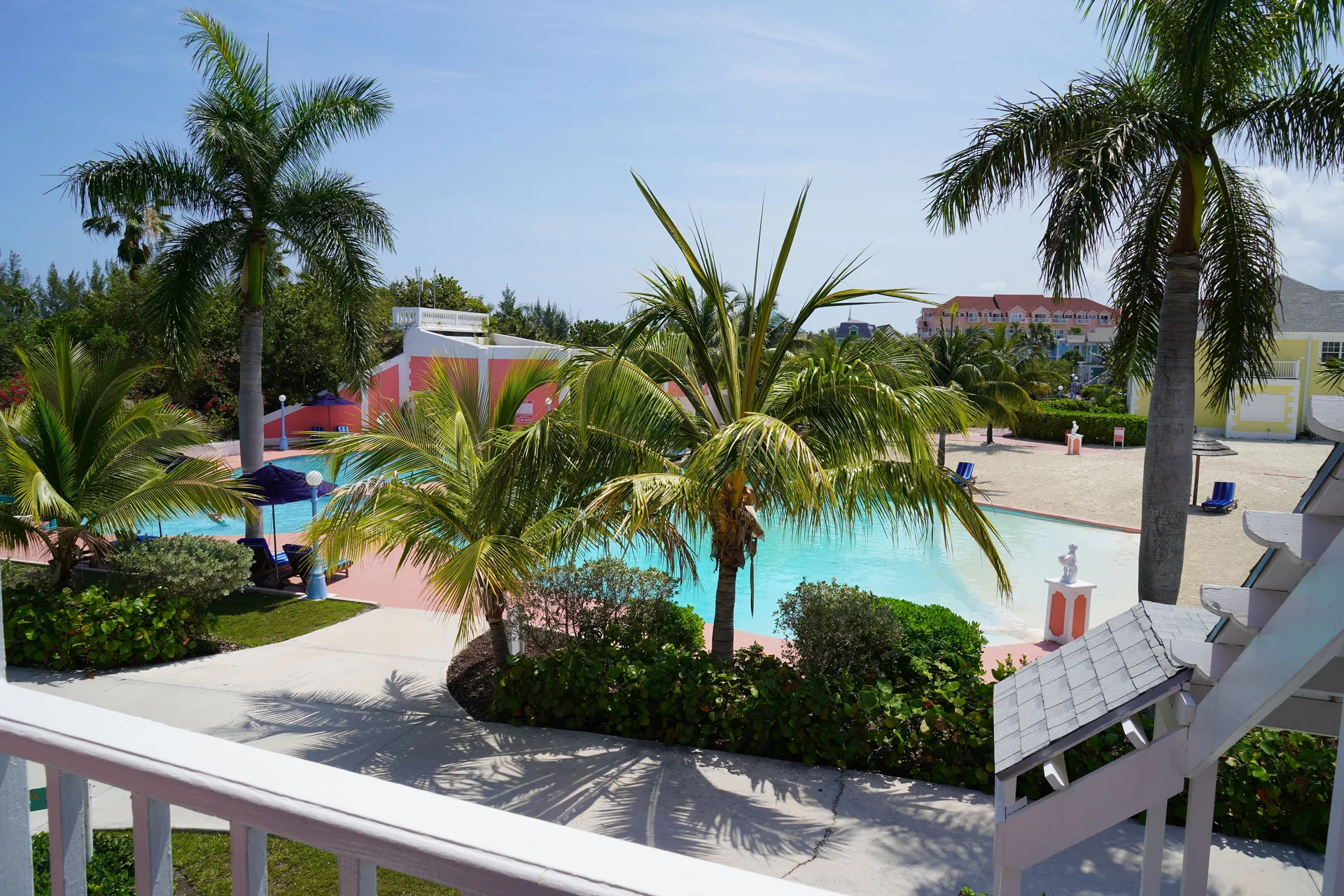 Standard Room balcony view of pool, palms, and resort grounds at Sandyport Beach Resort.