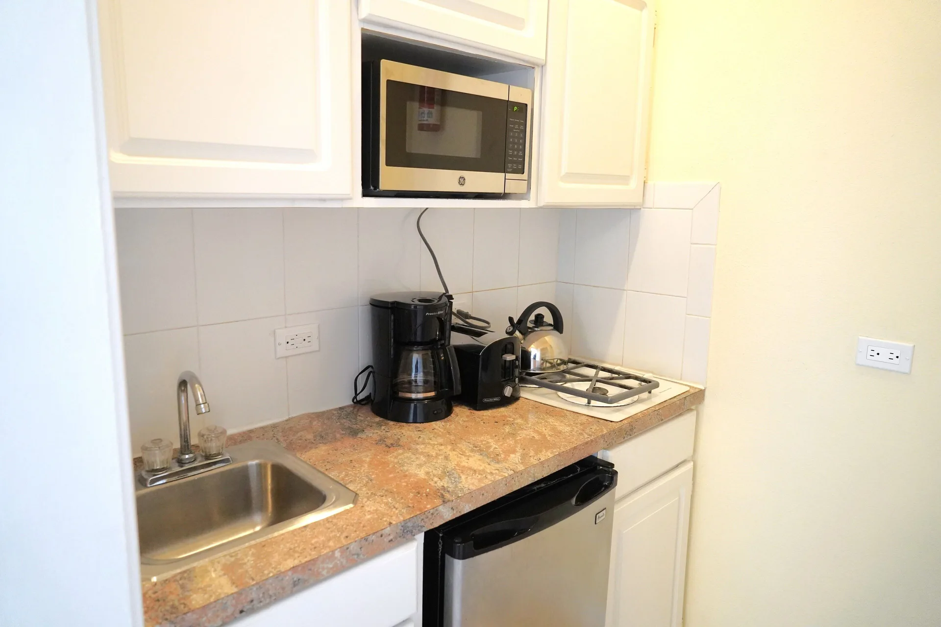 Standard Studio kitchenette with sink and appliances at Sandyport Beach Resort.