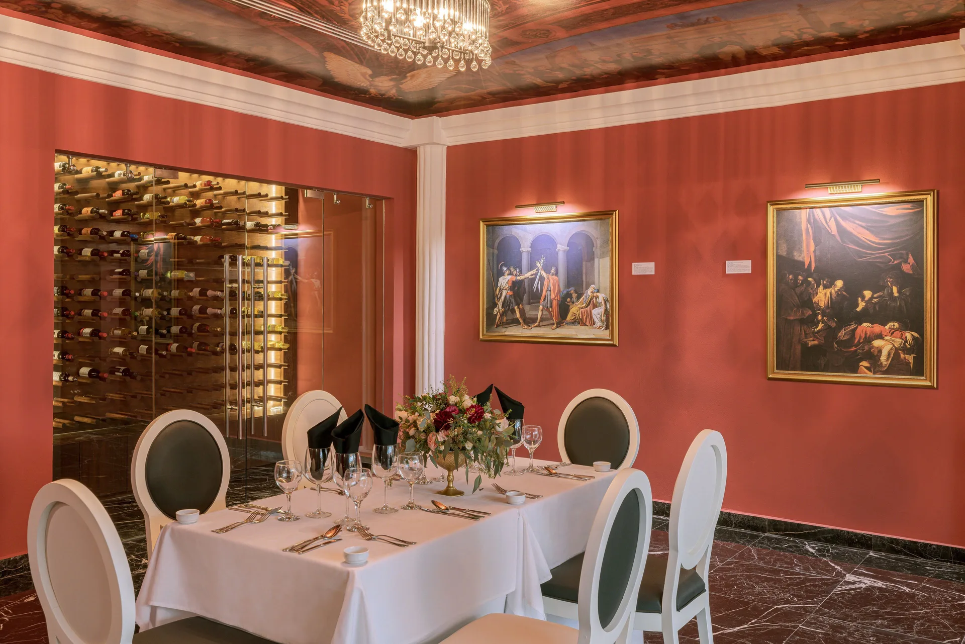 Red-walled dining room with wine display and paintings at Sensira Resort & Spa Riviera Maya.