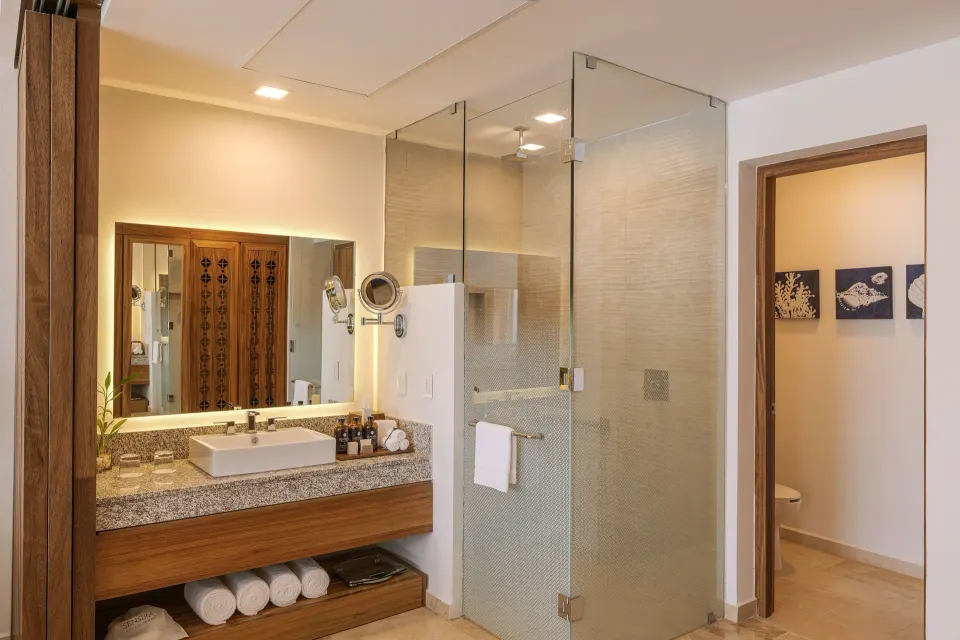 Agatha bathroom with vanity and glass shower at Sensira Resort & Spa Riviera Maya.