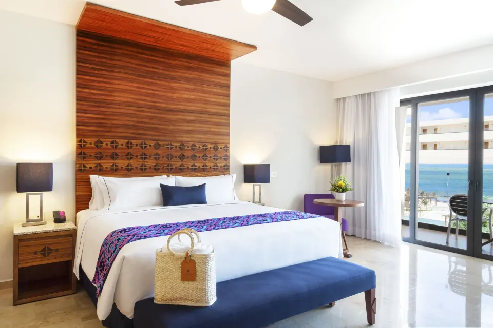 Agatha ocean-view king room with balcony doors at Sensira Resort & Spa Riviera Maya.