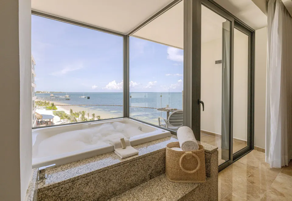 Amber Room soaking tub by corner windows with ocean view at Sensira Resort & Spa Riviera Maya.