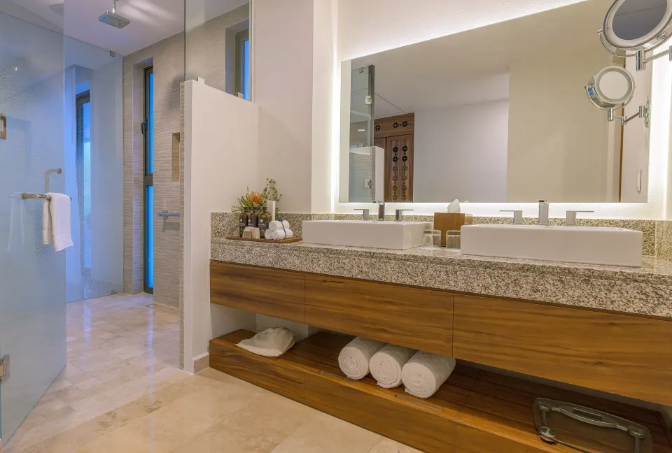 Ruby Suite bathroom with double sinks and glass shower at Sensira Resort & Spa Riviera Maya.