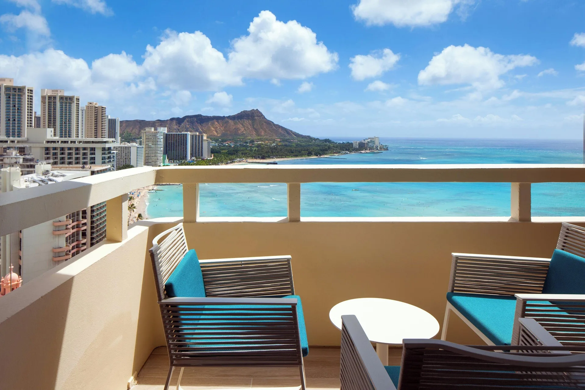 Furnished oceanfront balcony with Waikiki and Diamond Head views at Sheraton Waikiki Beach Resort.