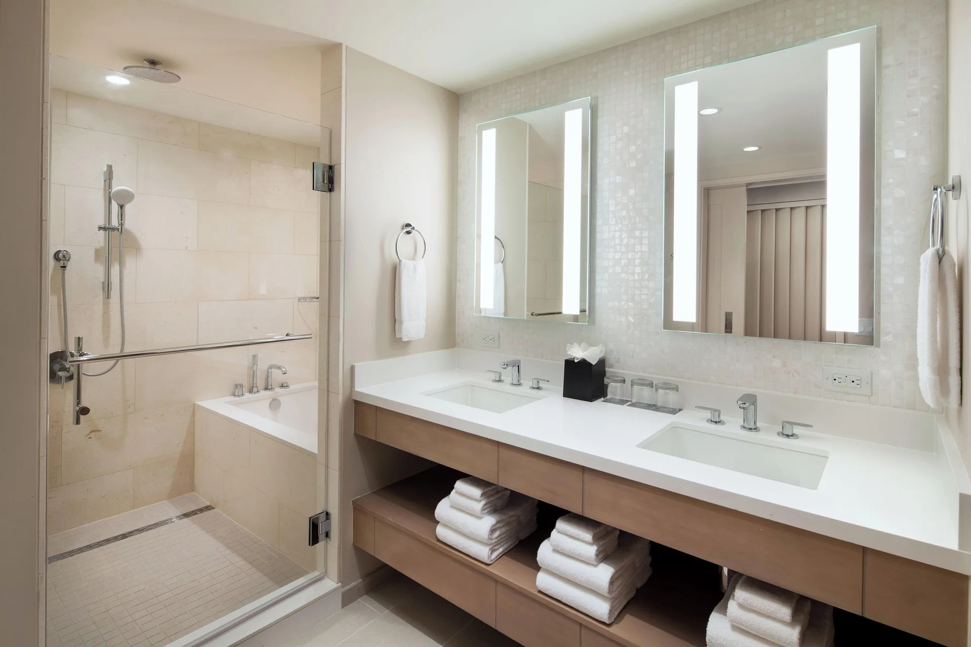 Bathroom with double vanity, lit mirrors, tub, and shower at Sheraton Waikiki Beach Resort.