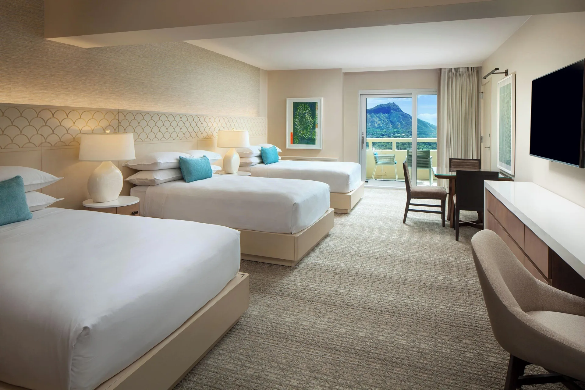 Oceanfront room with multiple beds and balcony view at Sheraton Waikiki Beach Resort.