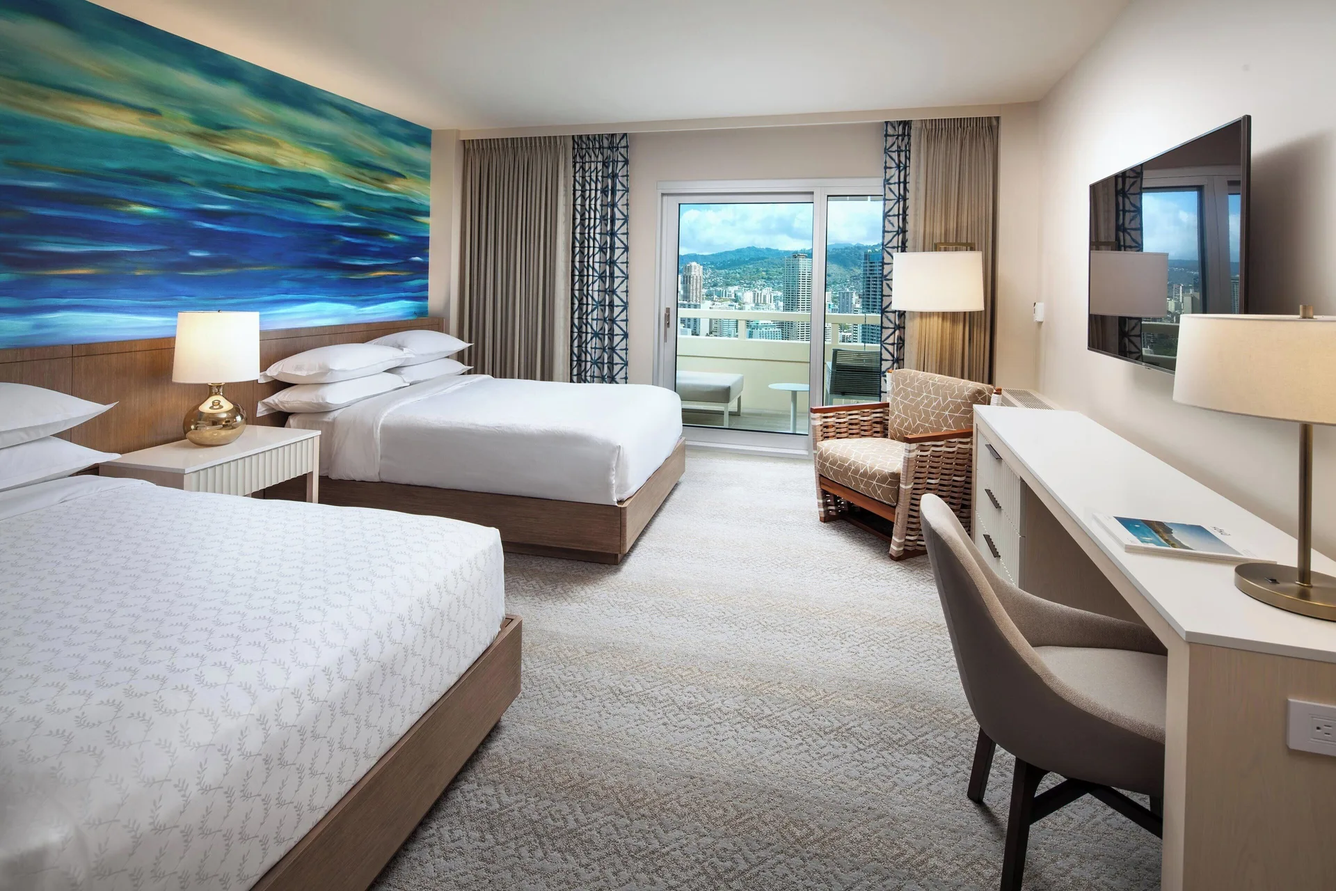 City View room with two beds, balcony, desk, and wall art at Sheraton Waikiki Beach Resort.