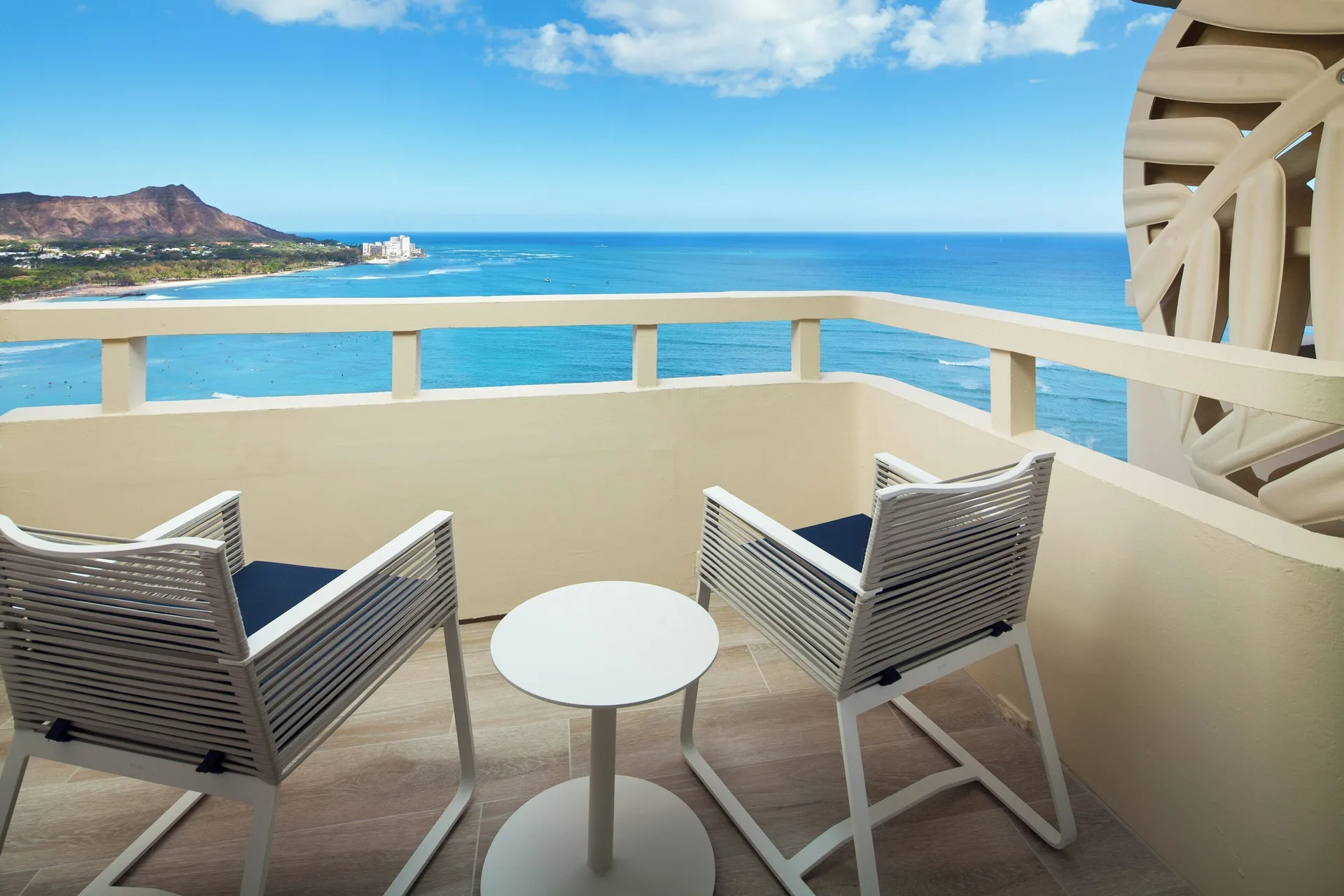 Oceanfront balcony with chairs and Diamond Head view at Sheraton Waikiki Beach Resort.