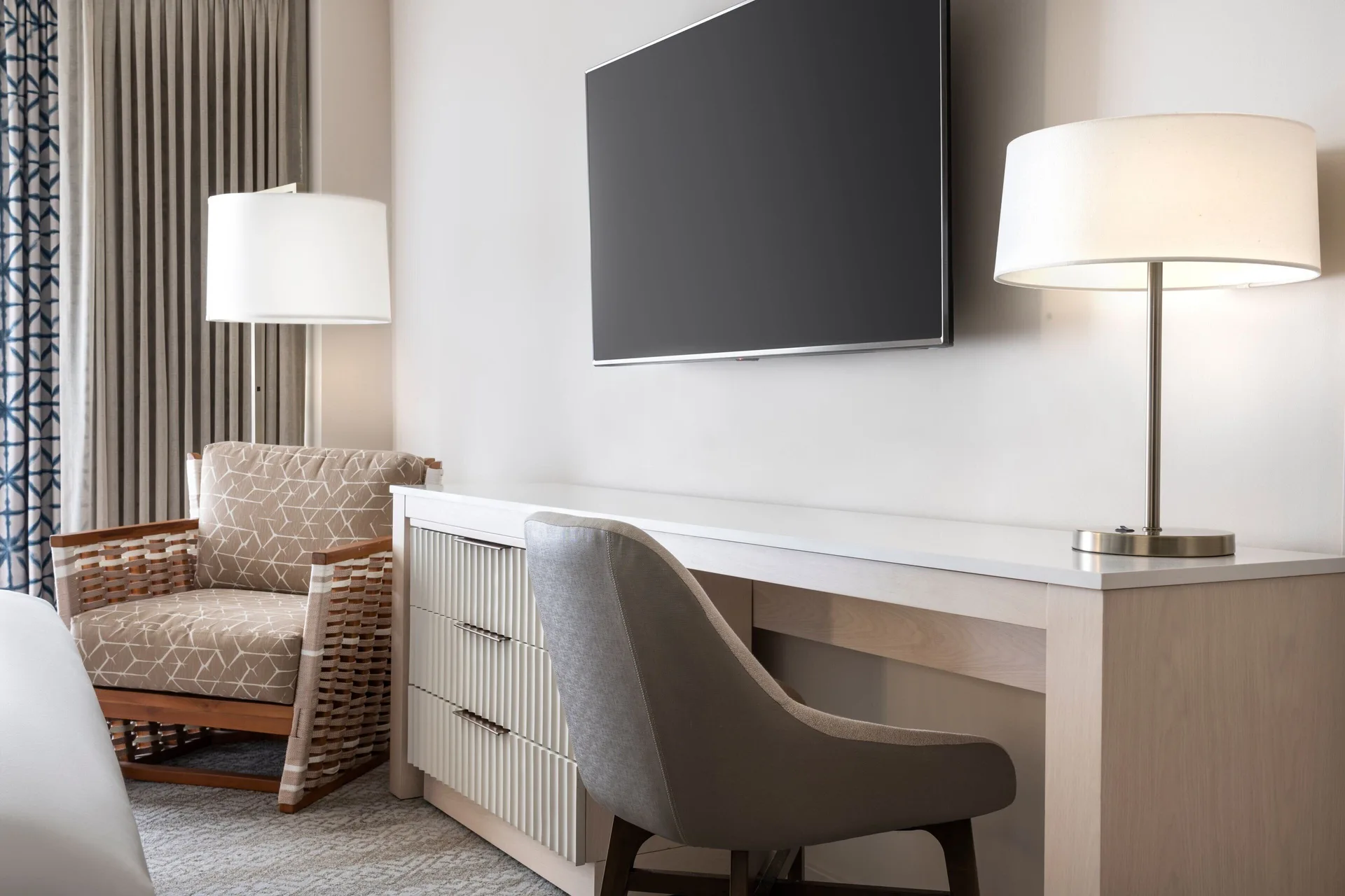 Oceanfront room desk, TV, and lounge chair at Sheraton Waikiki Beach Resort.