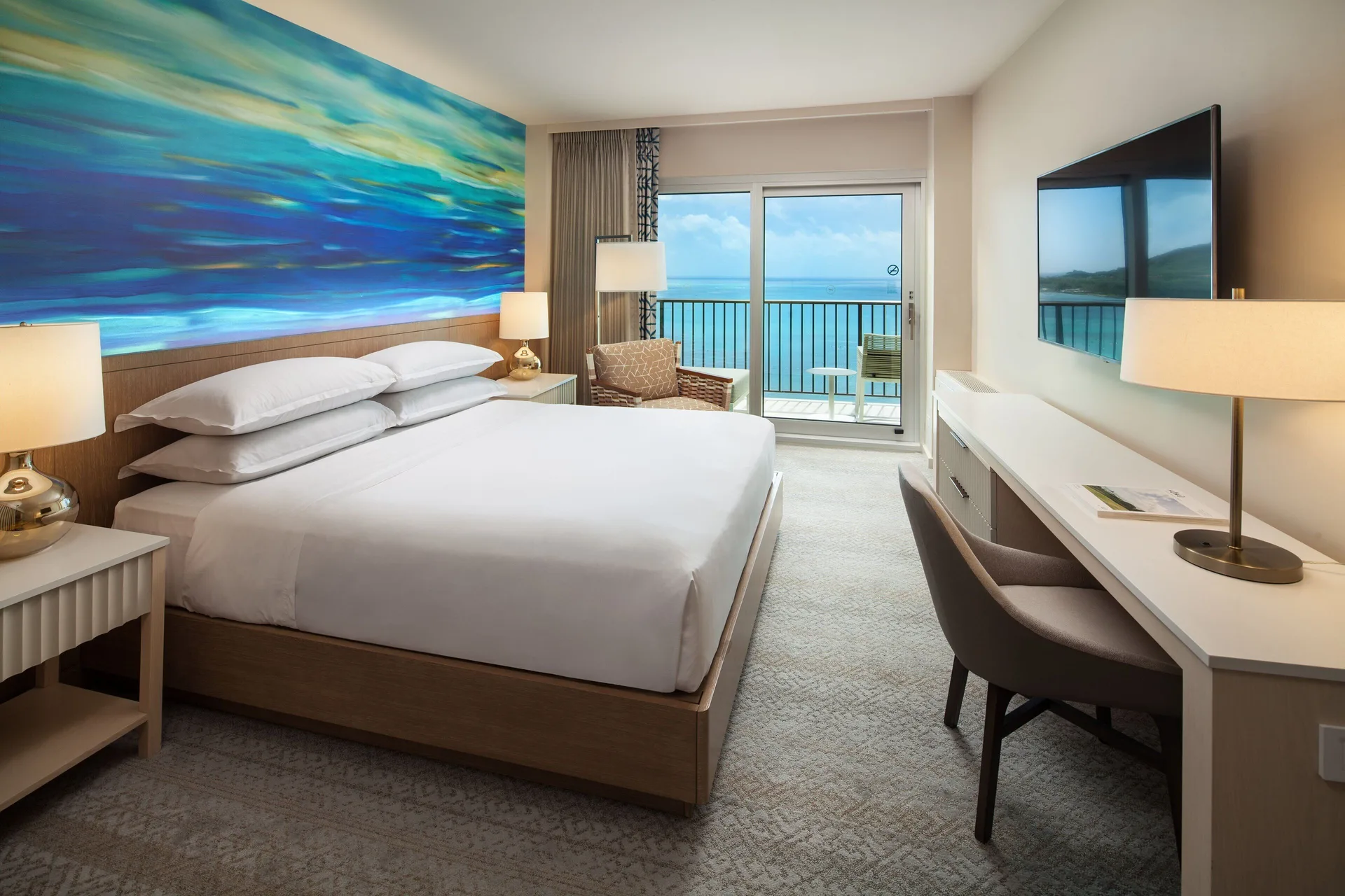 Oceanfront king guest room with balcony and sea view at Sheraton Waikiki Beach Resort.