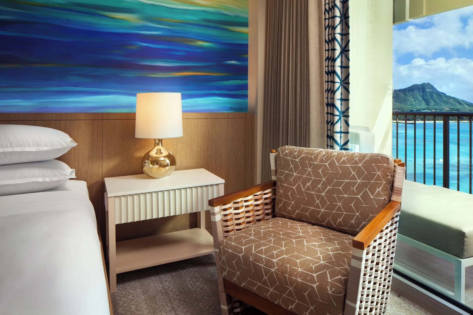 Guest room chair beside an oceanfront balcony at Sheraton Waikiki Beach Resort.
