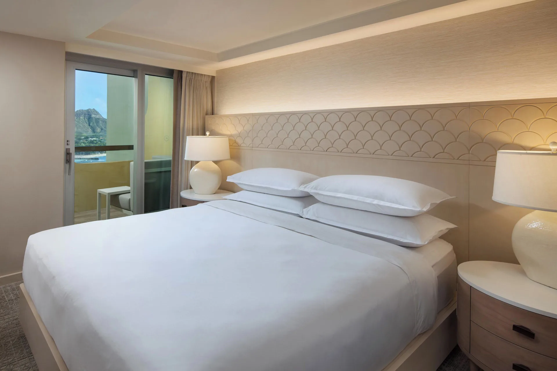 Malia Suite king bedroom with balcony doors at Sheraton Waikiki Beach Resort.