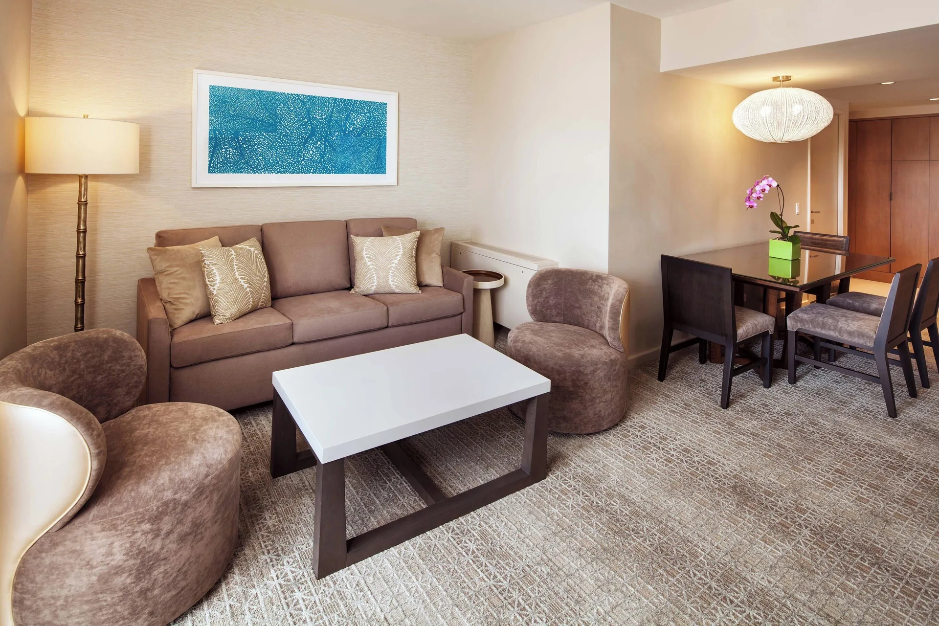 Malia Suite seating and dining area with sofa and table at Sheraton Waikiki Beach Resort.