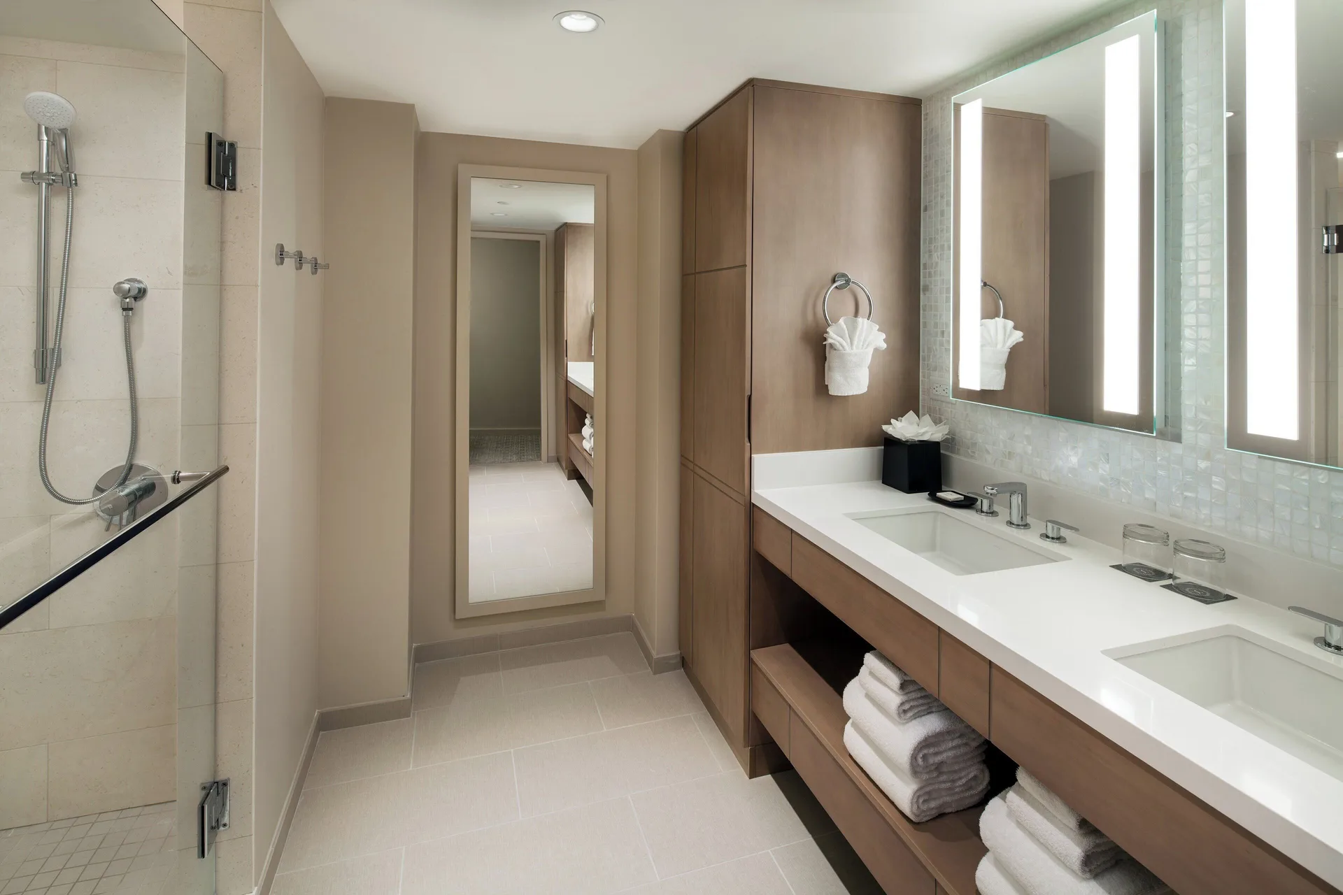 Ohana Suite bathroom at Sheraton Waikiki Beach Resort with double vanity and glass shower.