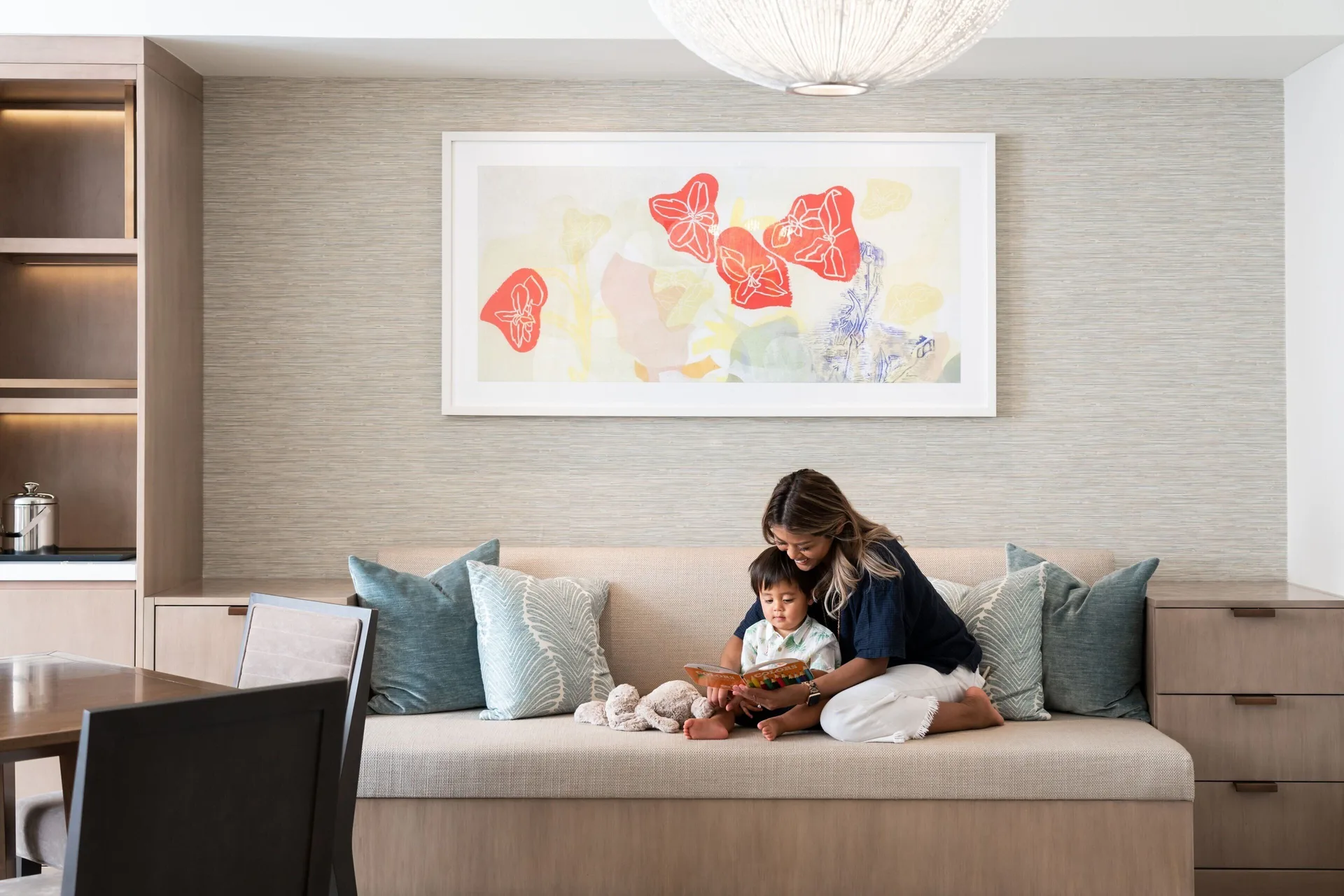 Ohana Suite living area at Sheraton Waikiki Beach Resort with bench seating and dining table.