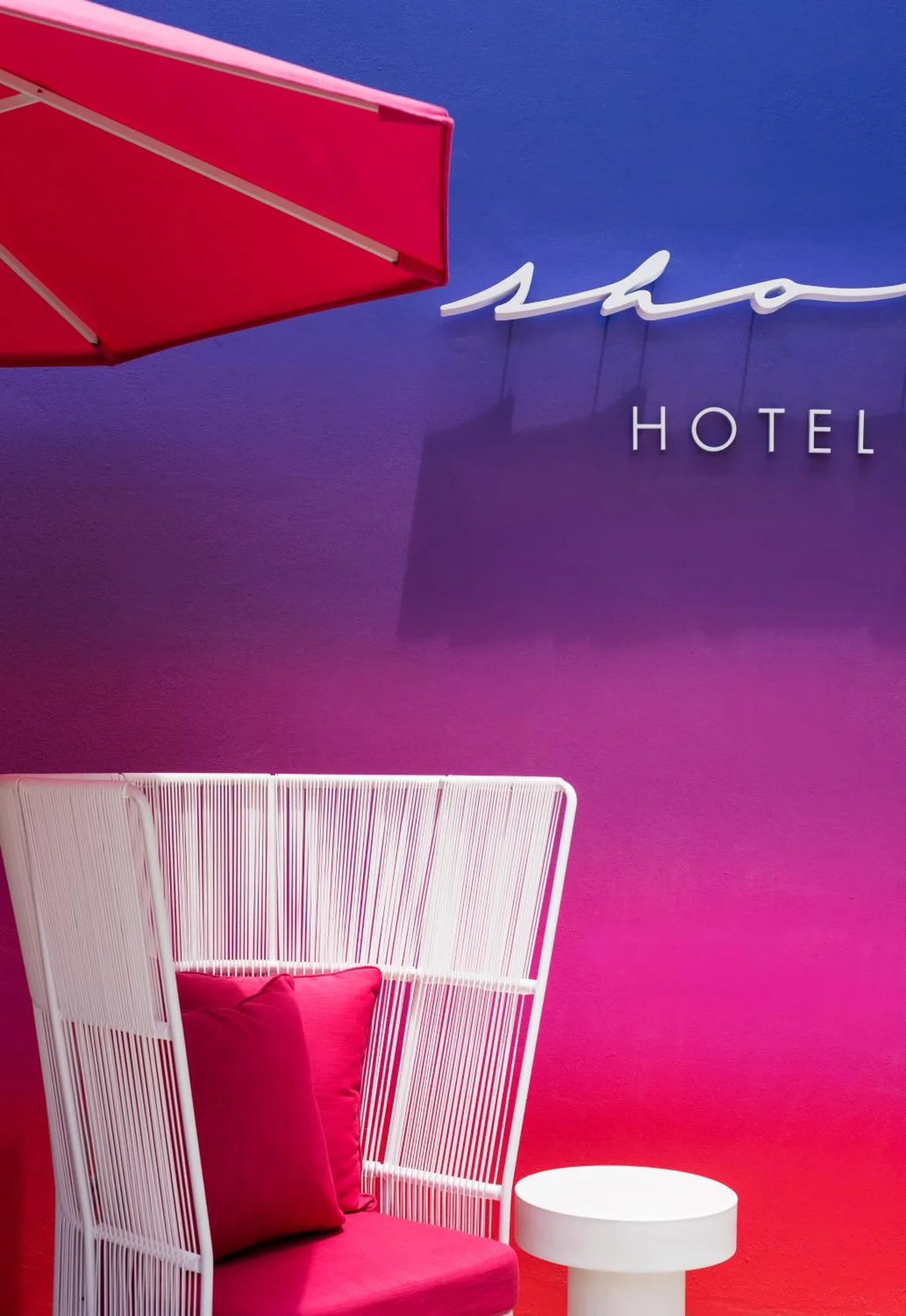 Colorful seating nook with hotel wall sign at Shoreline Hotel Waikiki.