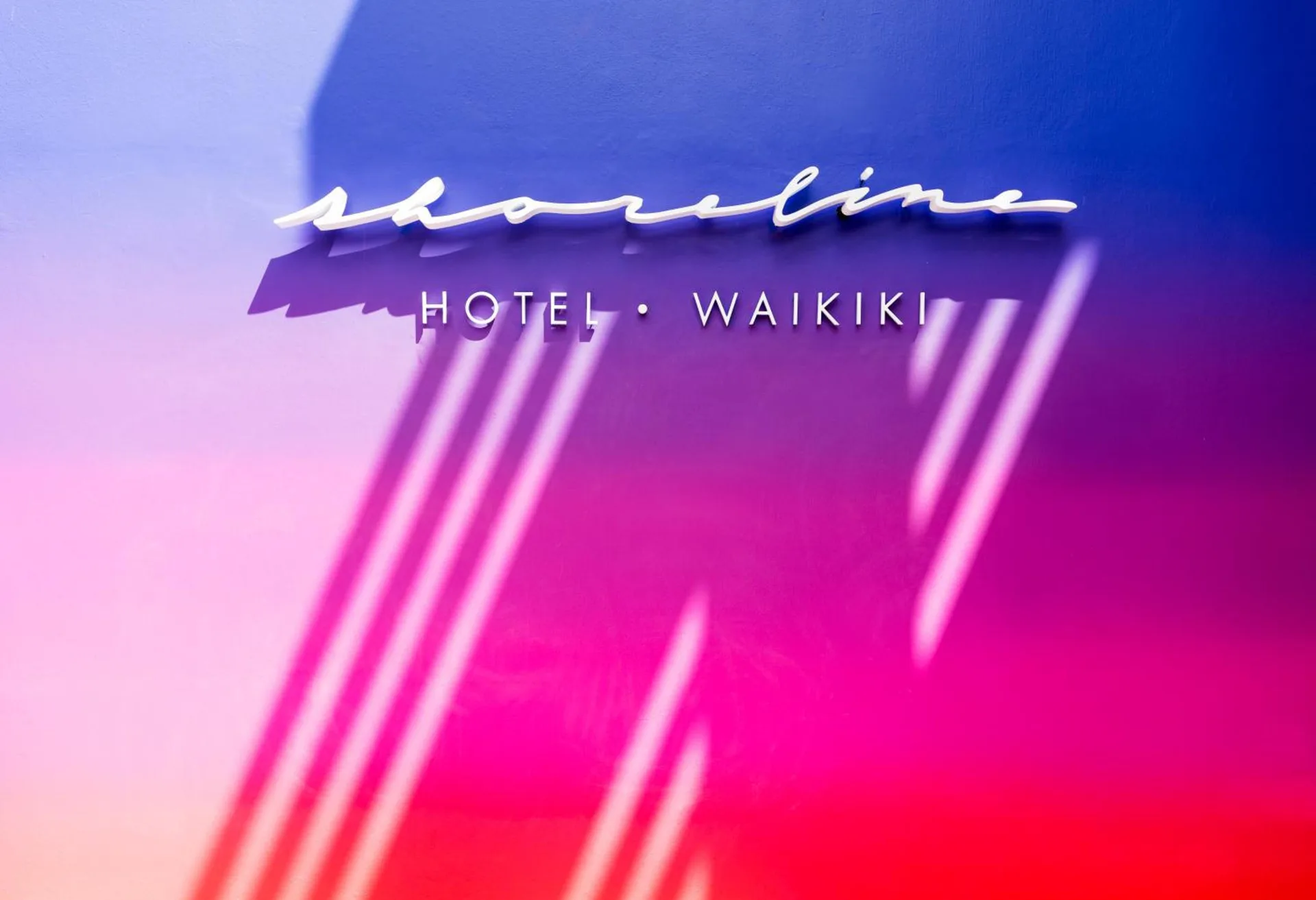 Exterior Shoreline Hotel Waikiki sign on a colorful wall at Shoreline Hotel Waikiki.