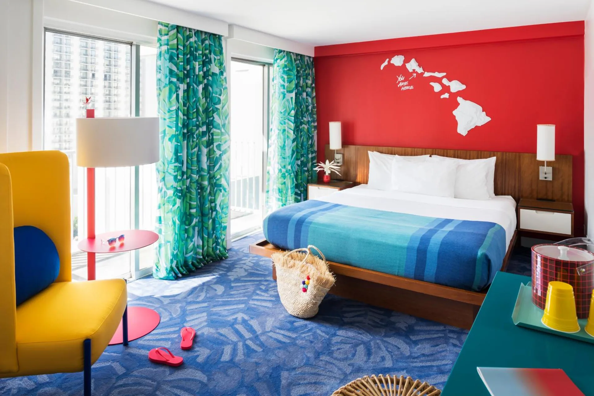 Guest room with king bed, yellow chair, and balcony doors at Shoreline Hotel Waikiki.