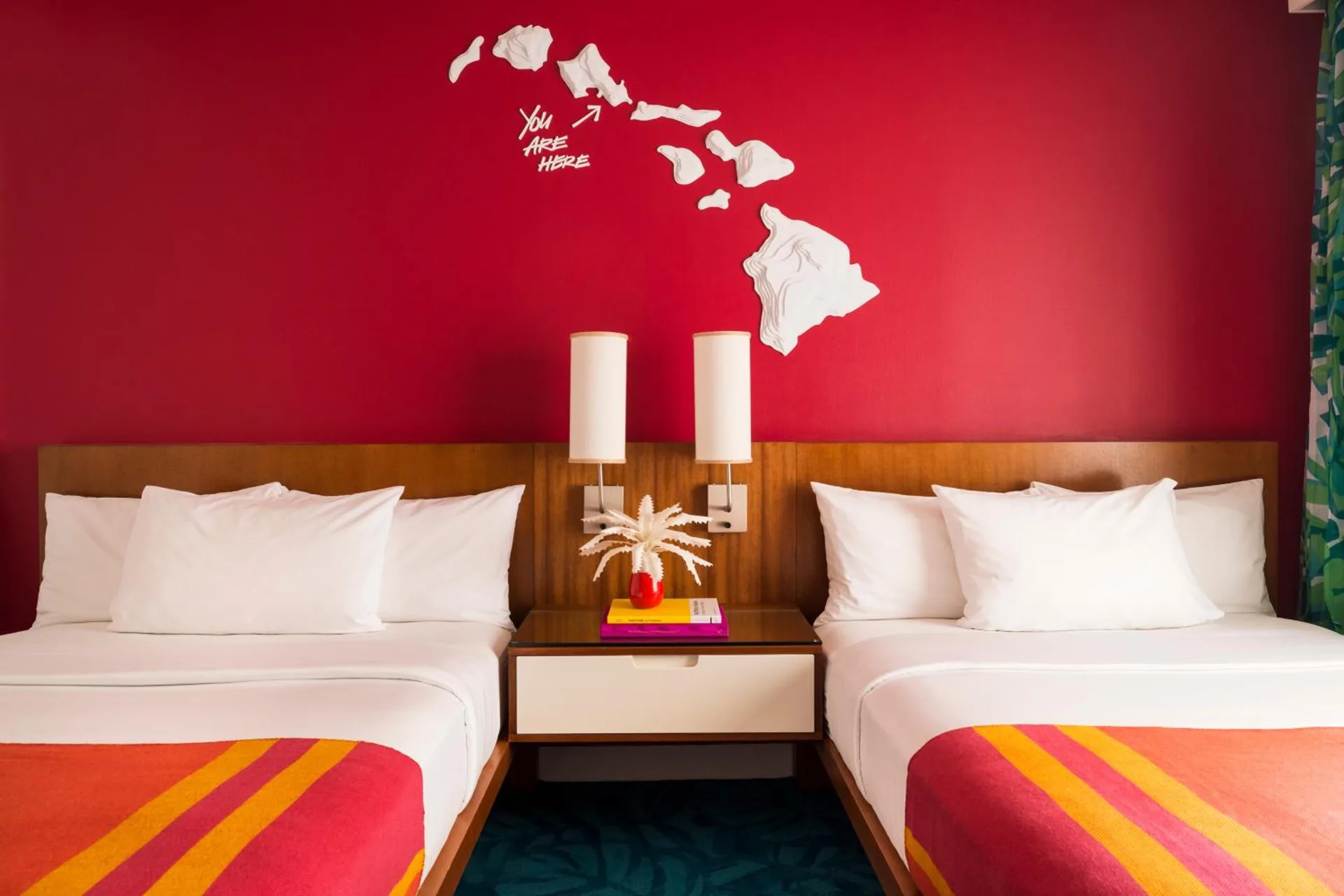 Guest room with two beds and a red island map wall at Shoreline Hotel Waikiki.