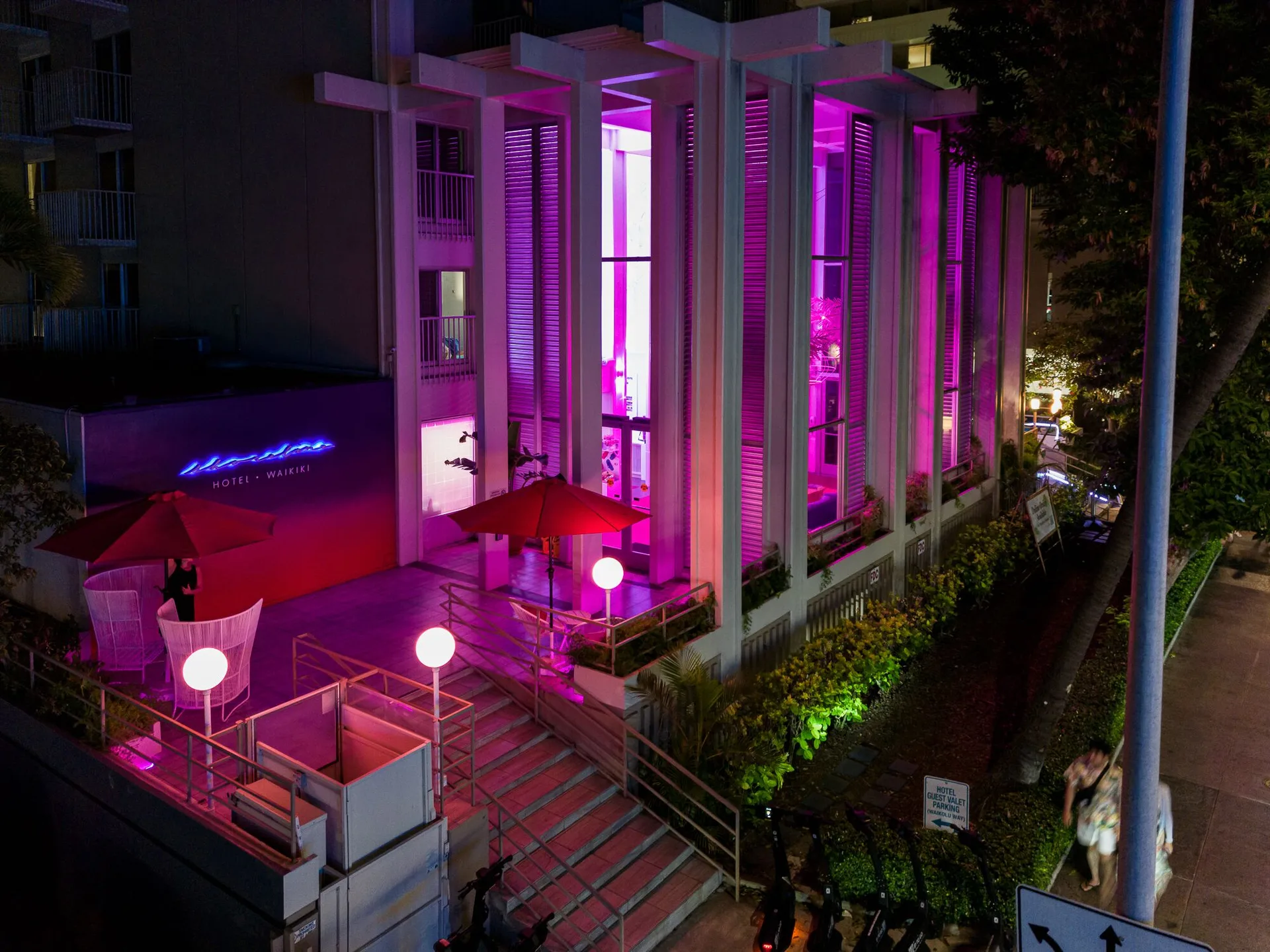 Night view of the illuminated entrance and facade at Shoreline Hotel Waikiki.