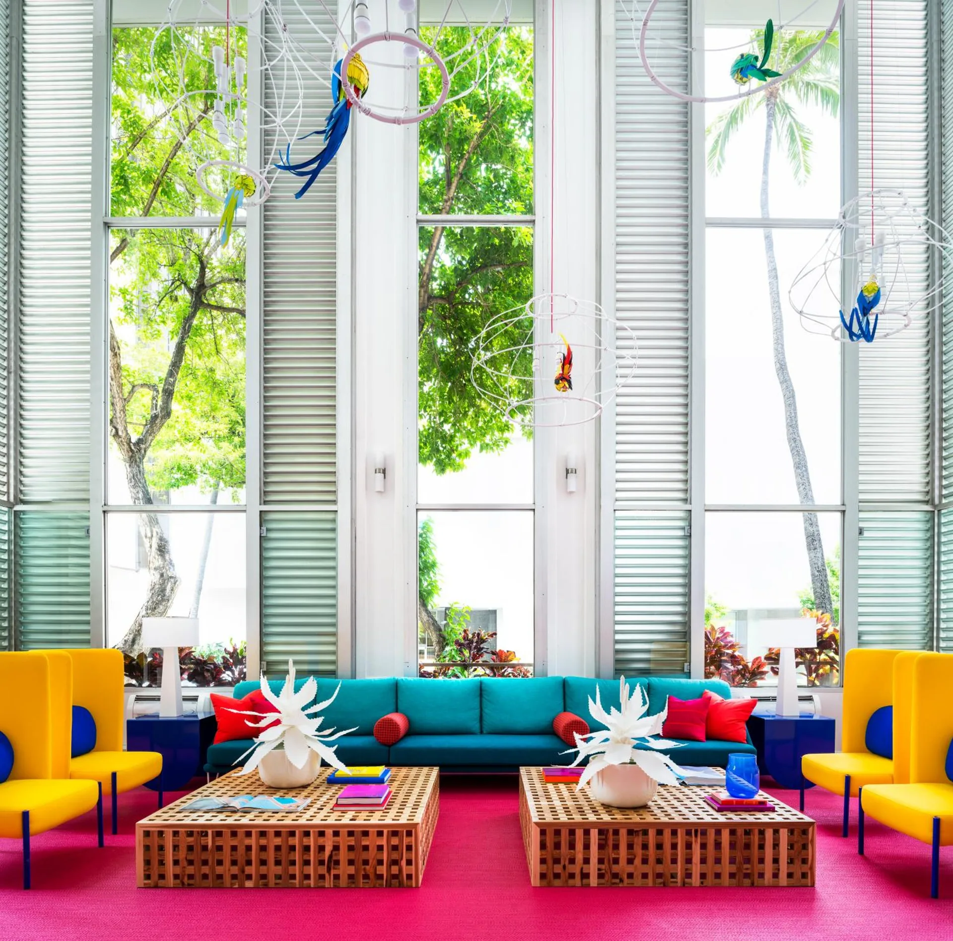 Bright lobby lounge with tall windows and colorful seating at Shoreline Hotel Waikiki.
