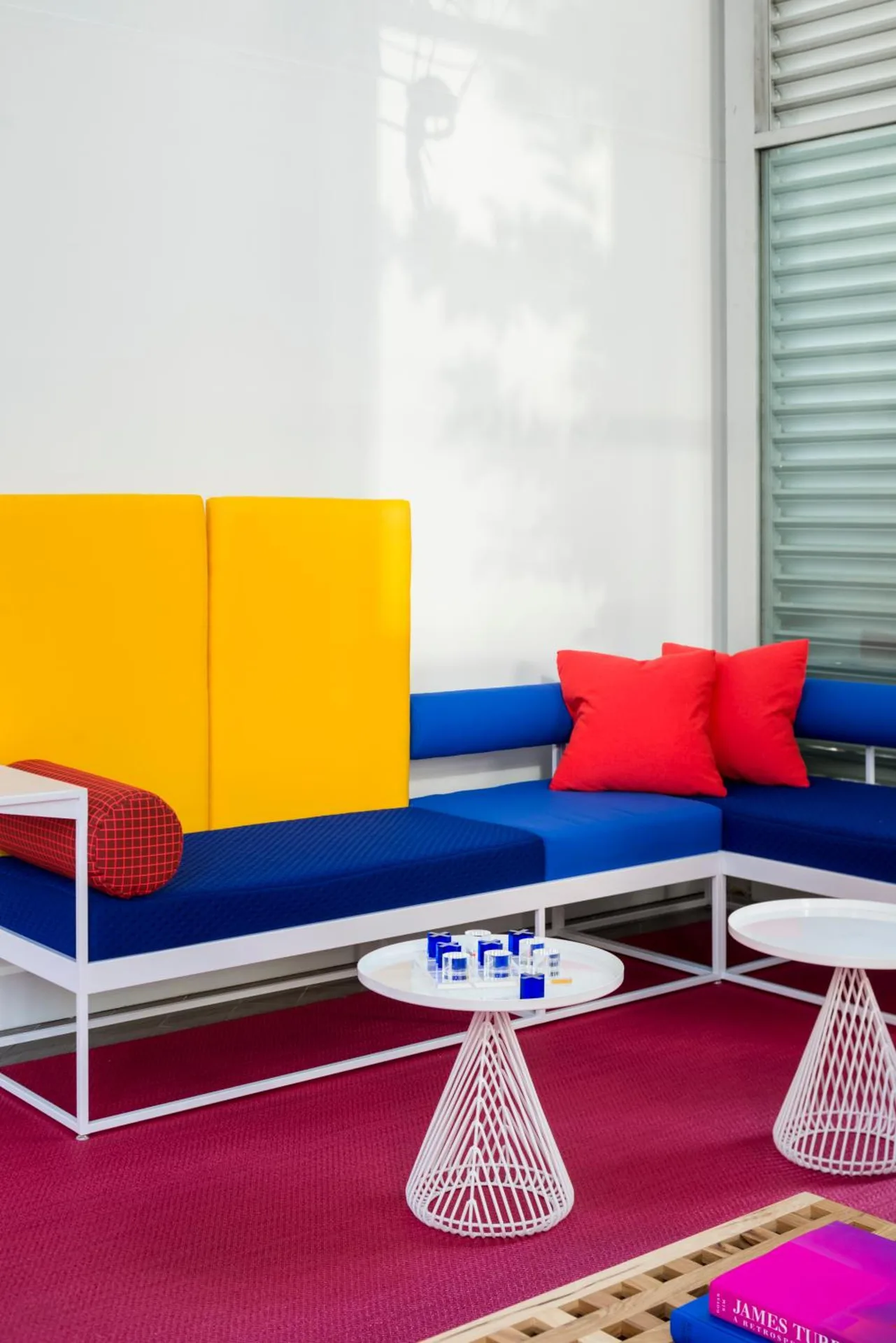 Lobby seating with blue cushions and red pillows at Shoreline Hotel Waikiki.