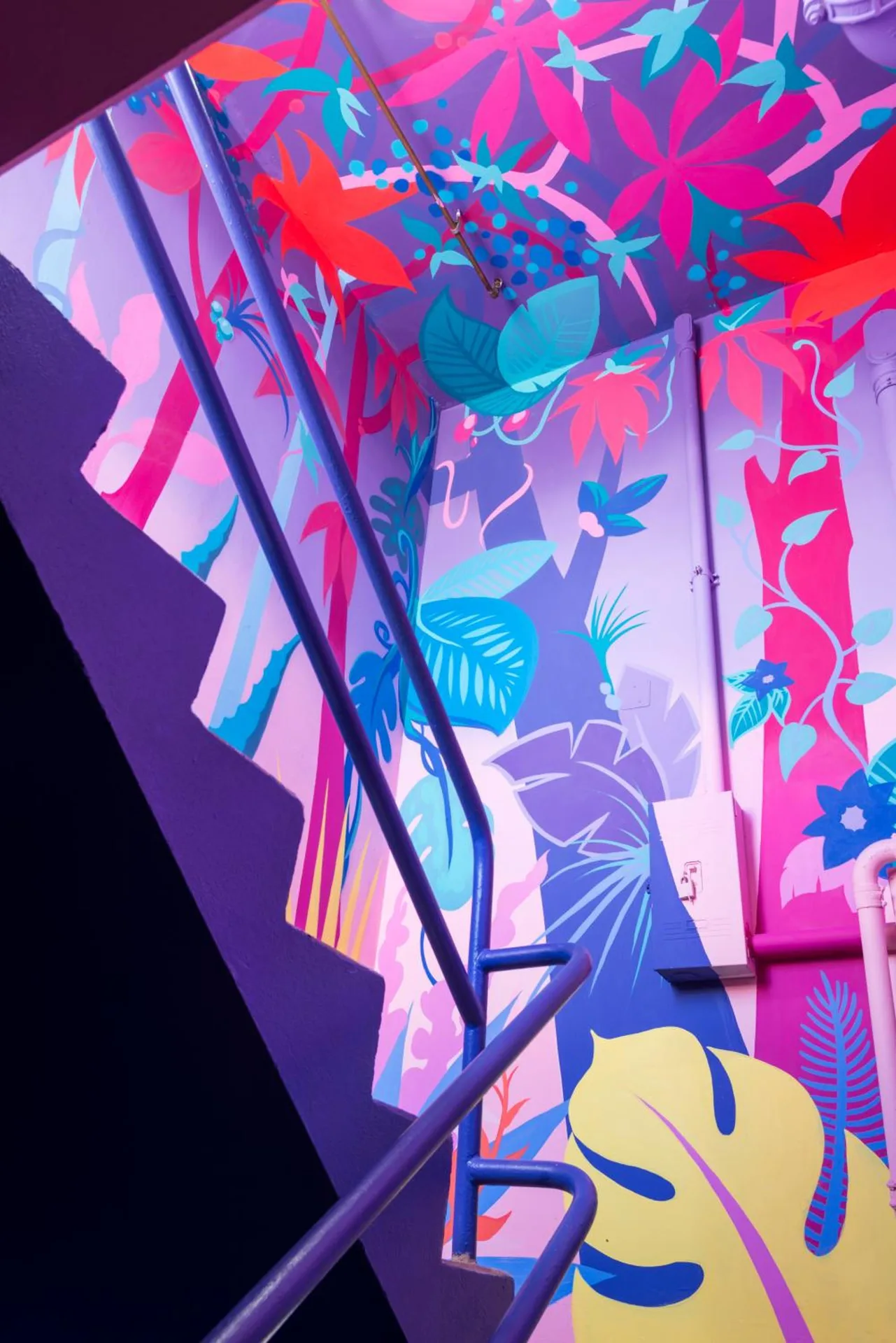Colorful tropical mural and stair railing inside Shoreline Hotel Waikiki.