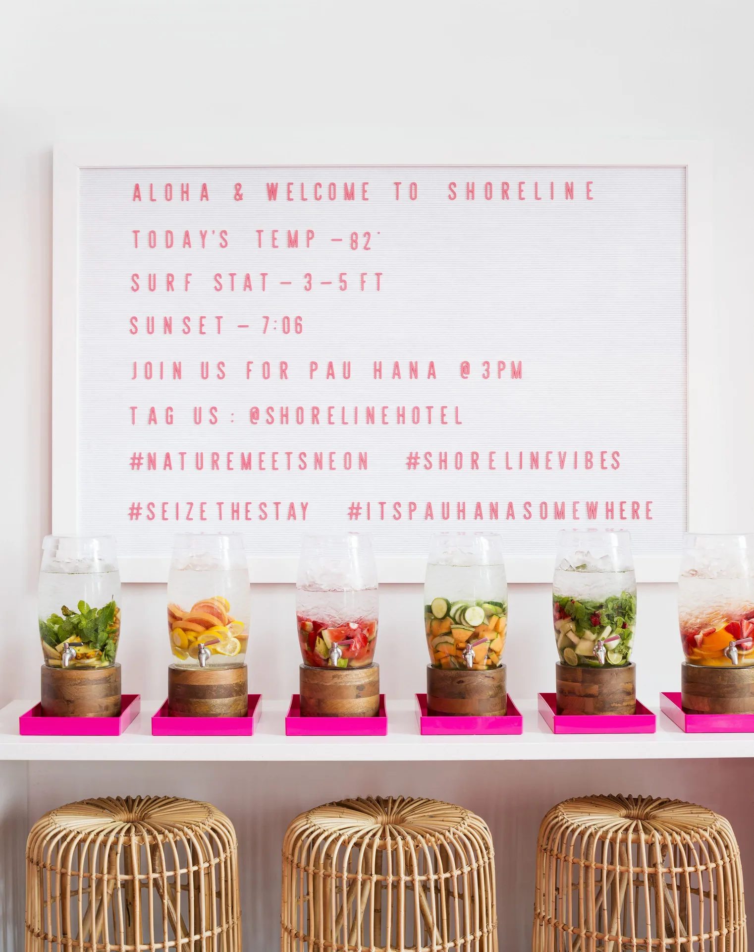 Welcome letter board and fruit-infused drink dispensers at Shoreline Hotel Waikiki.