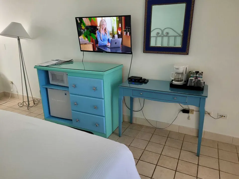 Courtyard View room dresser, TV, desk and coffee station at Sibonné Beach Hotel.