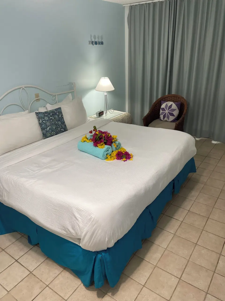 Courtyard View room bed with flowers and towel at Sibonné Beach Hotel.