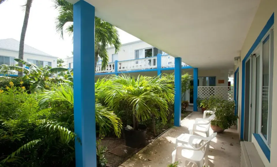 Courtyard view room patio with blue columns and tropical plants at Sibonné Beach Hotel.