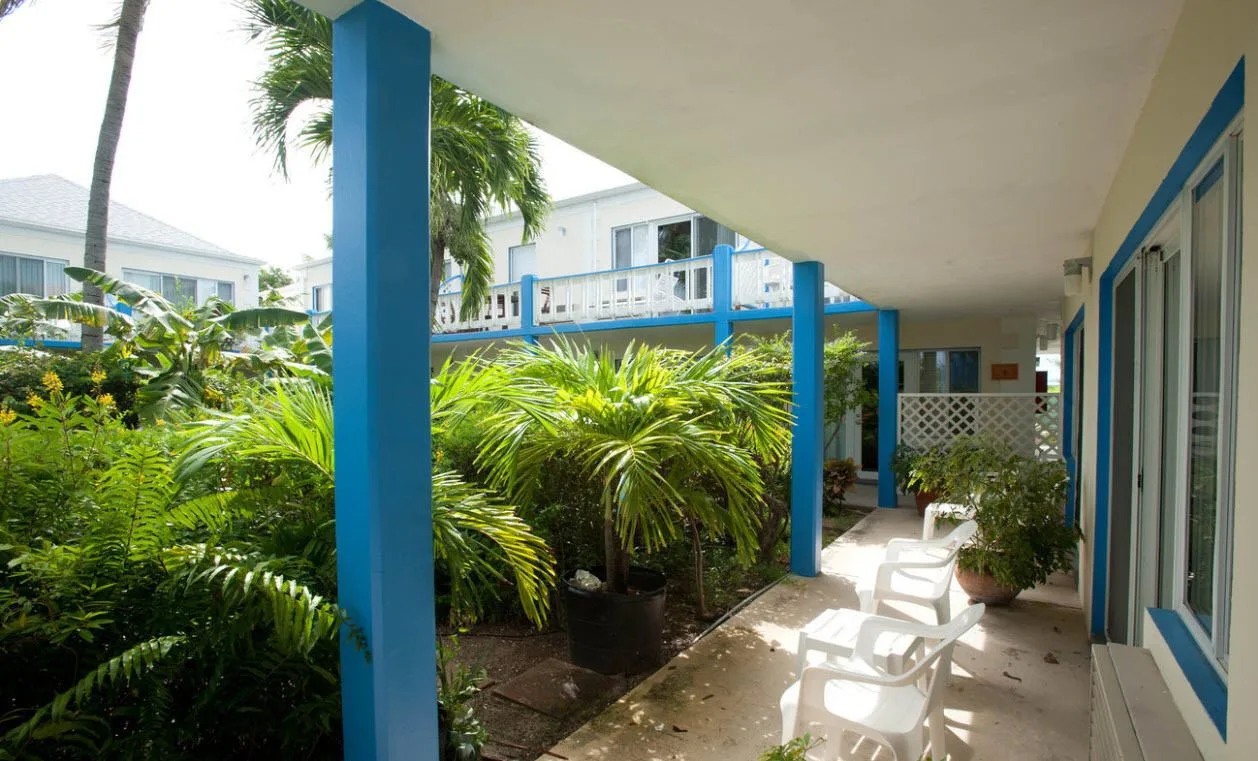 Courtyard view room patio with blue columns and tropical plants at Sibonné Beach Hotel.