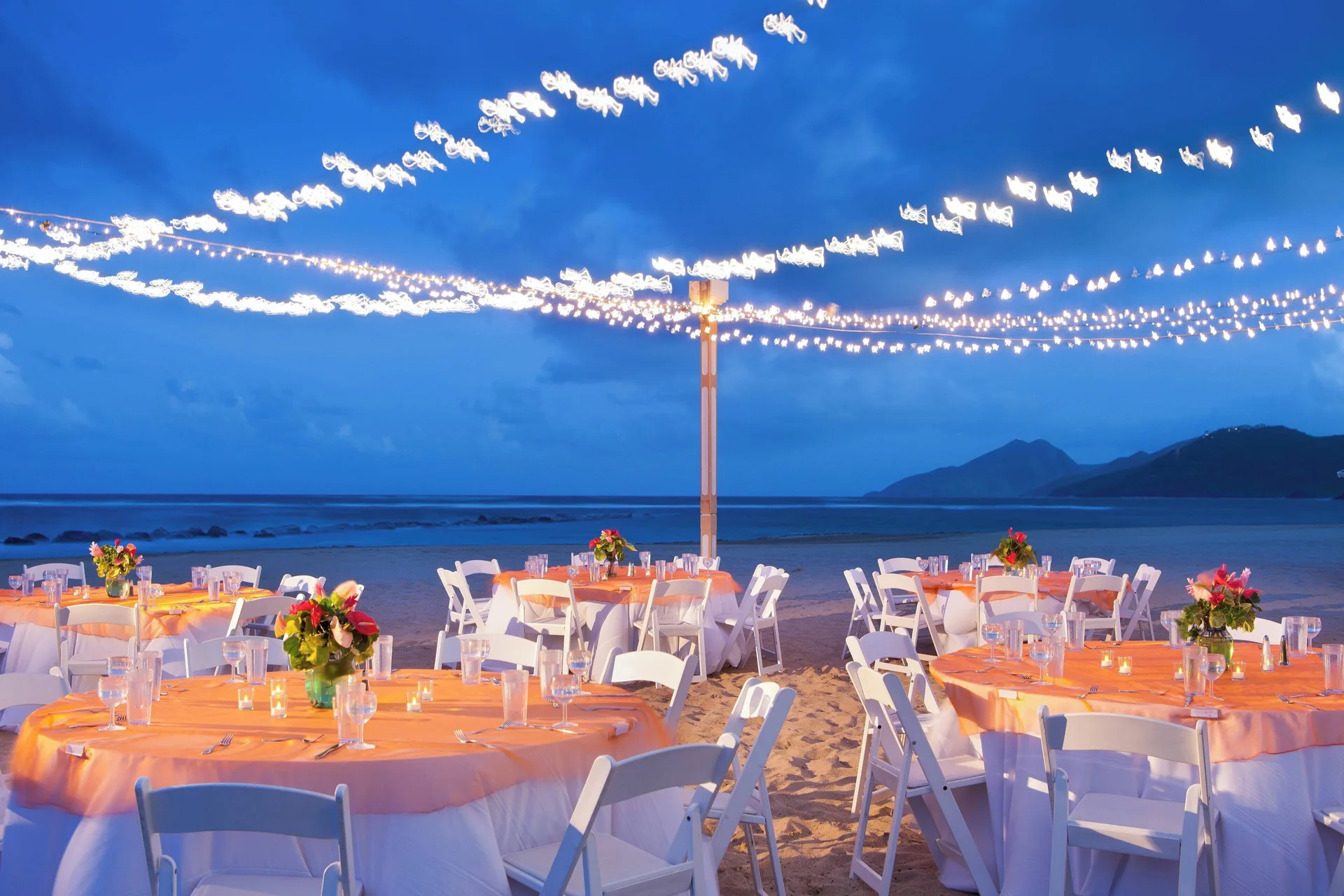 Beach dinner tables under string lights at St Kitts Marriott Beach Resort, Casino & Spa.