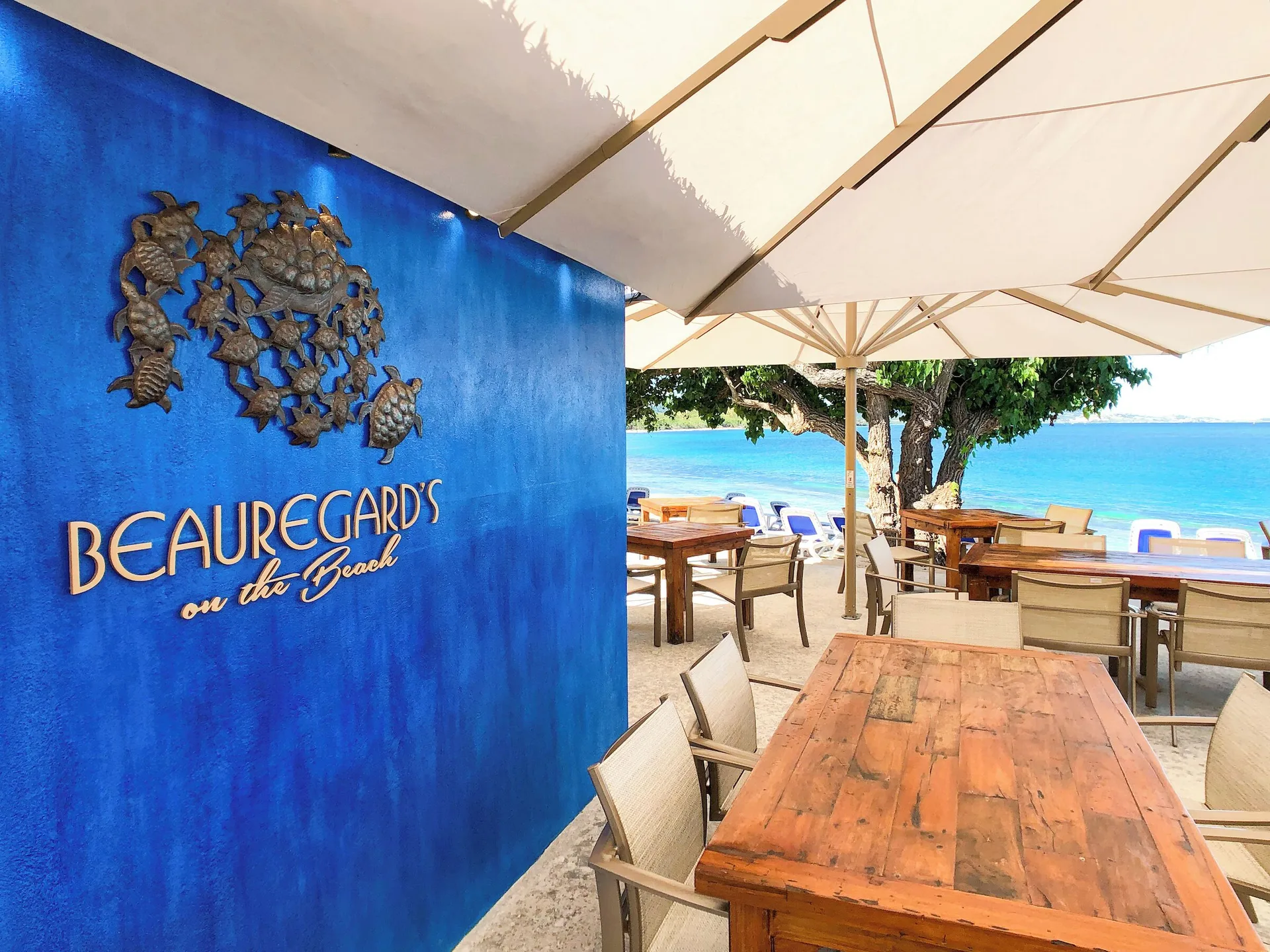 Beauregard's on the Beach sign and seaside tables at The Buccaneer Beach & Golf Resort.