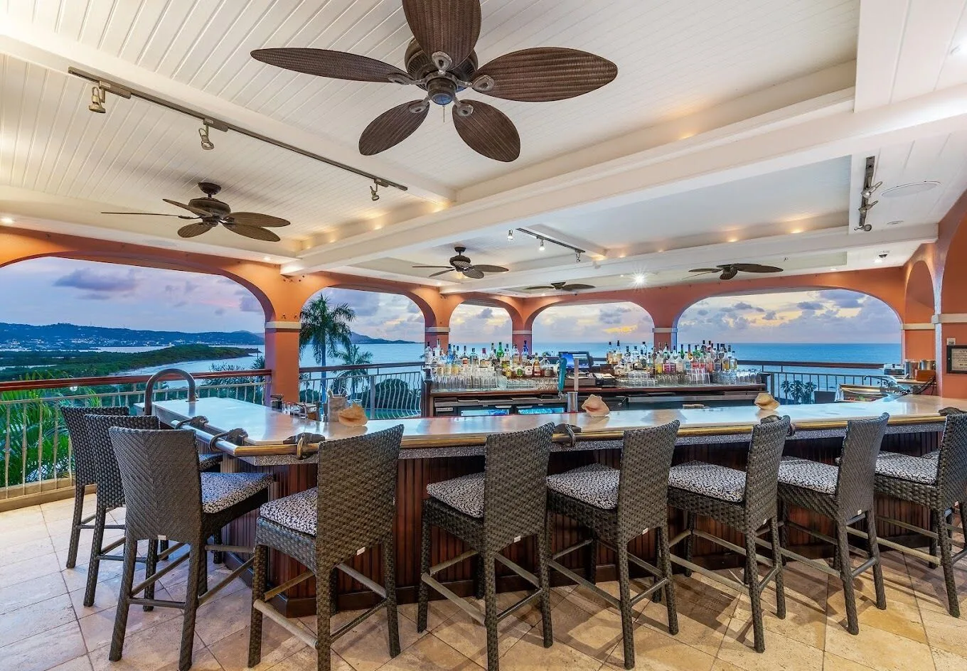 Open-air bar with ocean and island views at The Buccaneer Beach & Golf Resort.