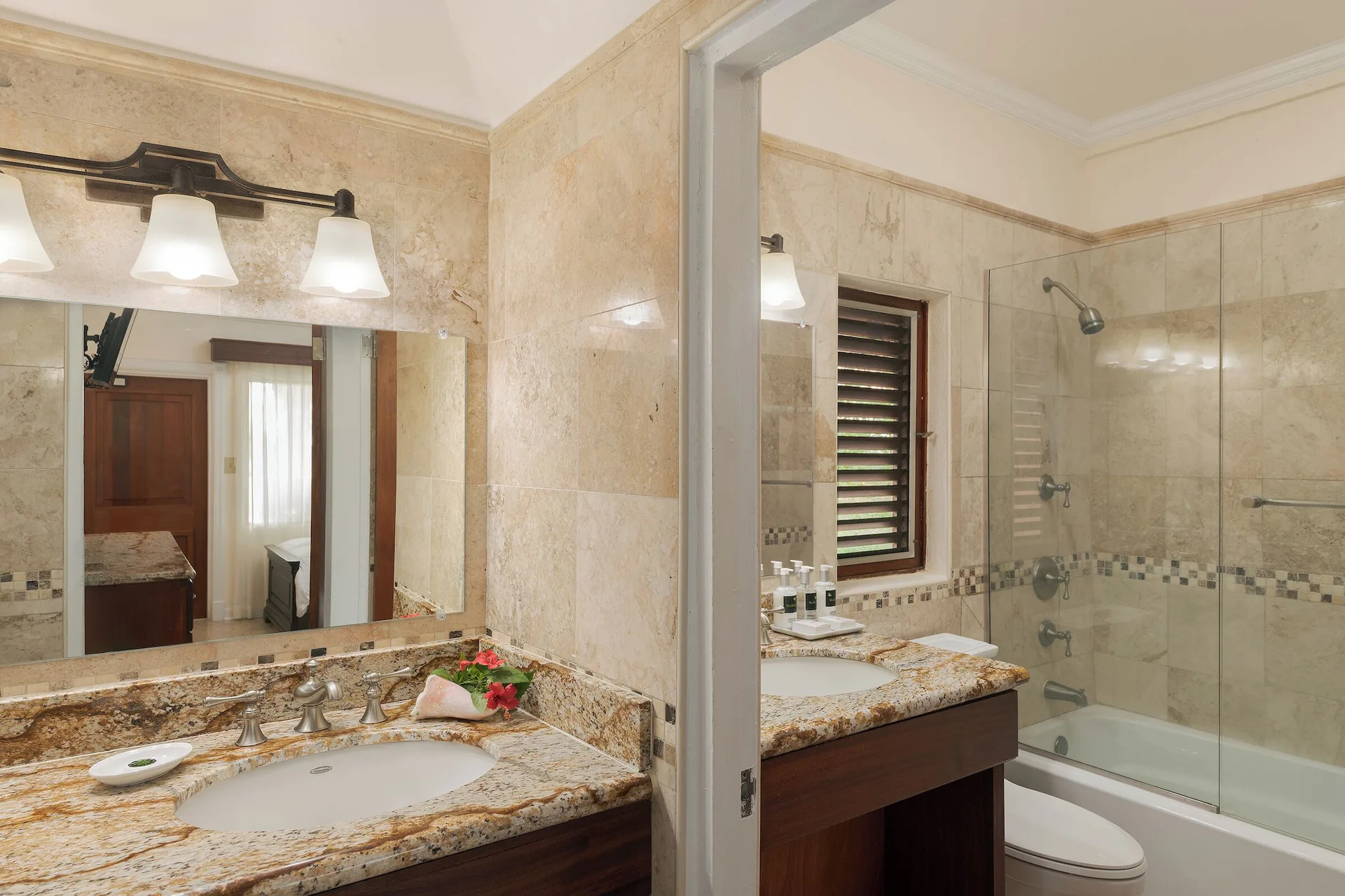 Family Suite cottage bathroom with granite vanities and tub shower at The Buccaneer Beach & Golf Resort.