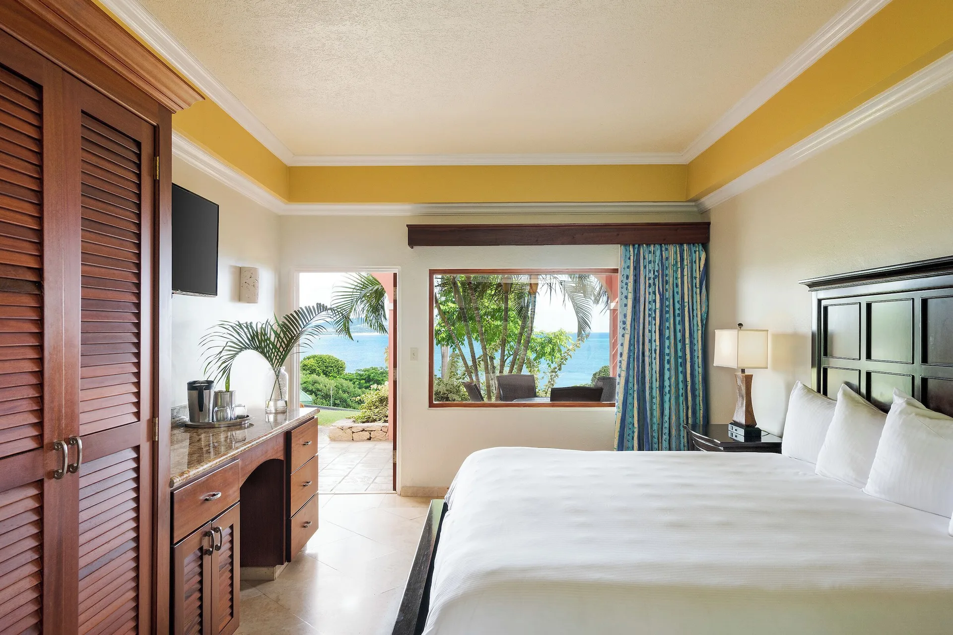 Family Suite cottage king bedroom with patio and ocean view at The Buccaneer Beach & Golf Resort.