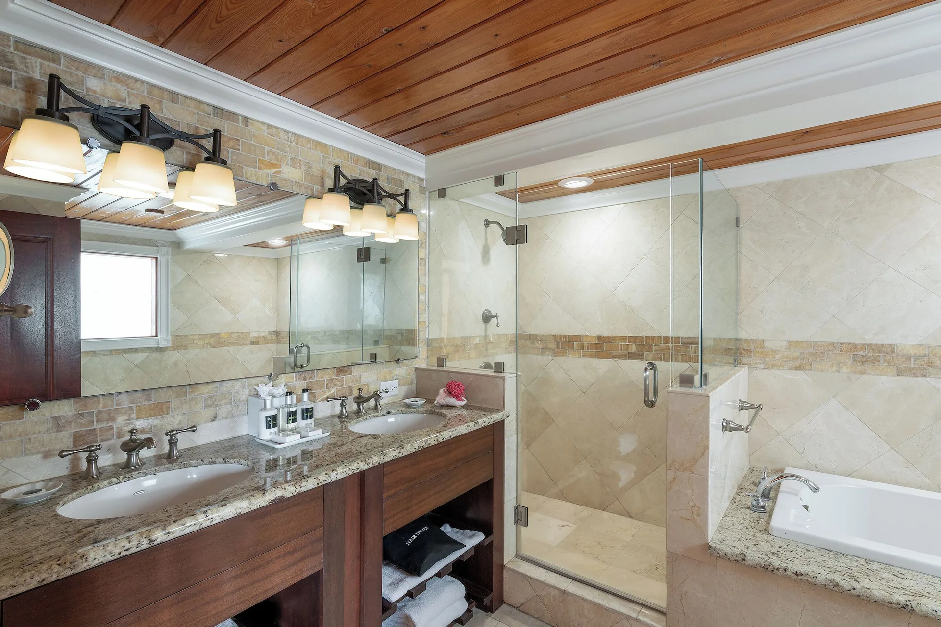 Ficus Suite bathroom with double vanity and glass shower at The Buccaneer Beach & Golf Resort.